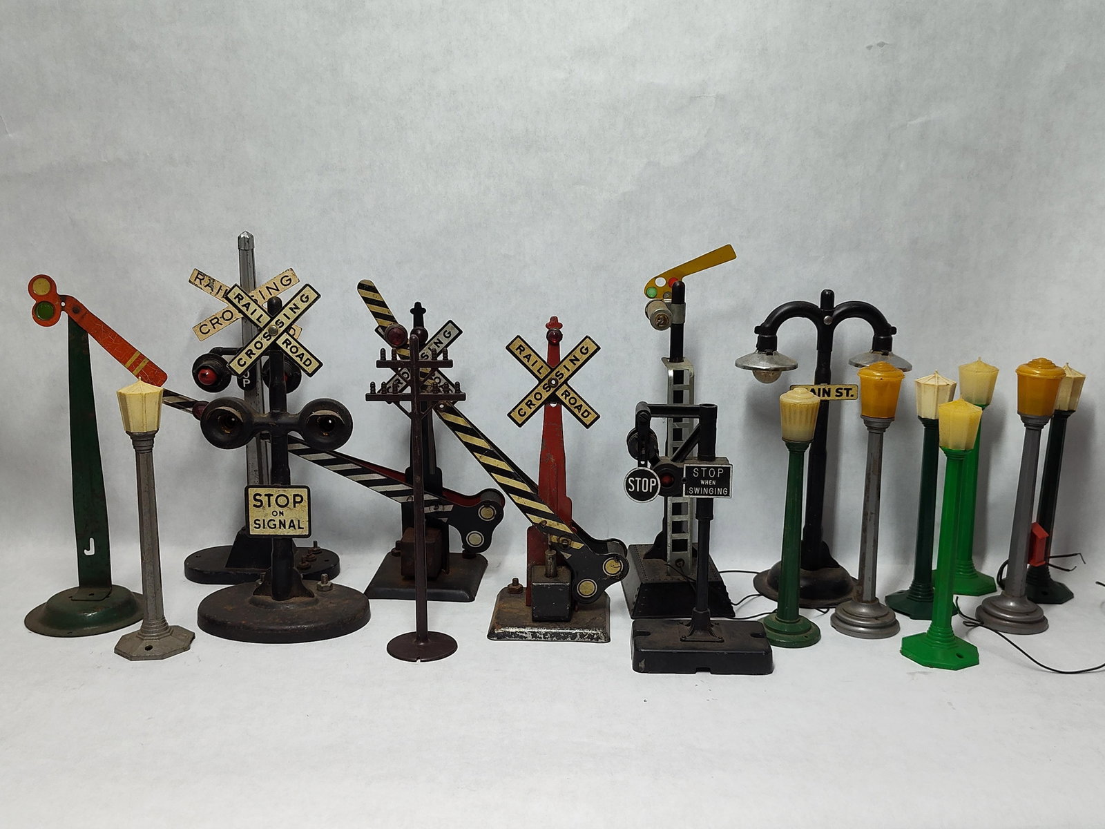 Marx & Lionel Attrib. 13 RR Signals & Access: This collection of thirteen model railroad signals and street accessories is attributed to mid-20th century manufacturers such as Marx and Lionel, designed for O-gauge or similar model train layouts.