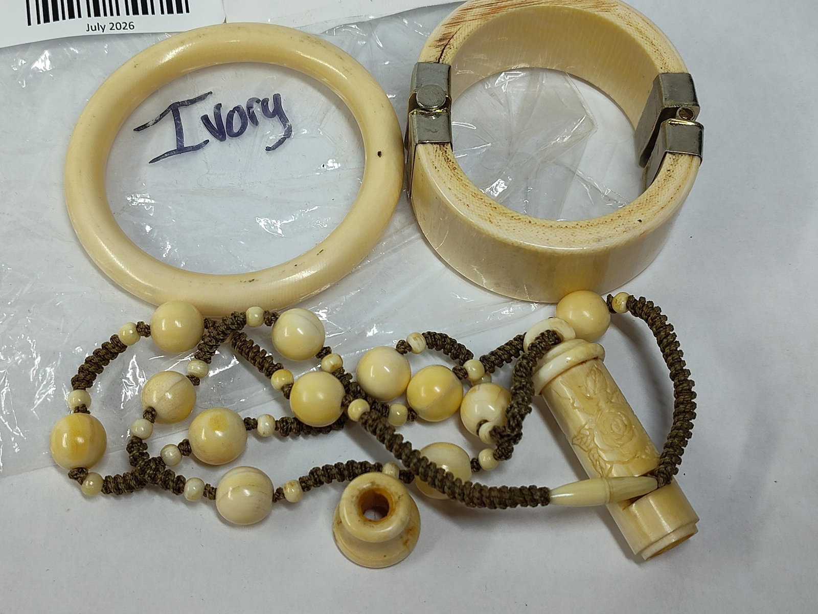 Ivory Jewelry: Bangles & Whistle Necklace: This collection consists of jewelry items and components composed of cream-colored organic material consistent with ivory. The lot features a simple circular bangle with a rounded profile and smooth