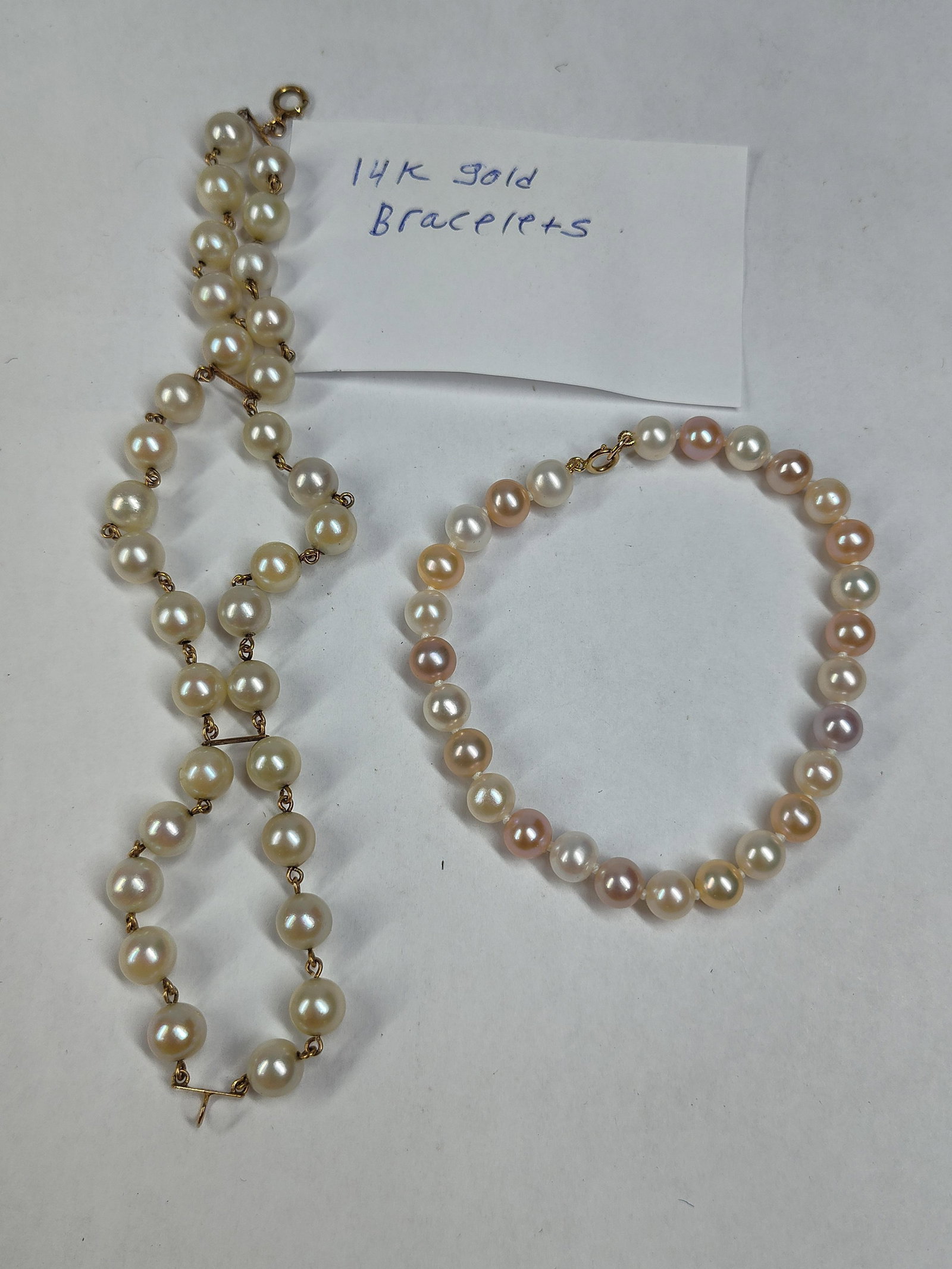 Caribe & 14k Gold Cultured Pearl Bracelets, Pair: This lot consists of two cultured pearl bracelets featuring 14-karat yellow gold hardware. The first is a double-strand link bracelet manufactured by Caribe. It features two strands of cream-colored,