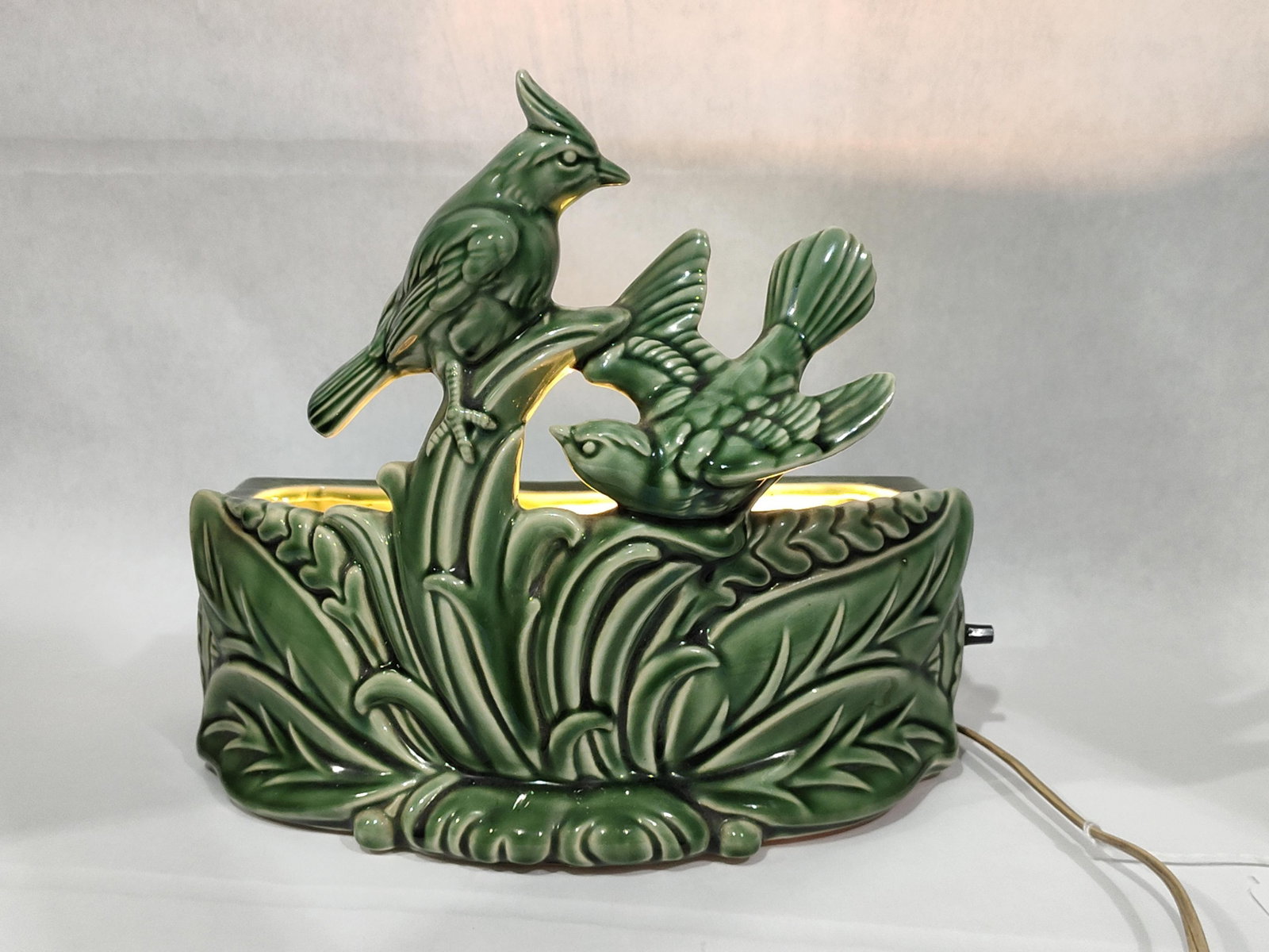 Mid-Century Green Ceramic Bird TV Lamp & Planter: A mid-century modern ceramic TV lamp and planter, attributed to American Art Potteries. This sculptural piece is crafted from earthenware and finished in a deep, glossy monochromatic green glaze. The