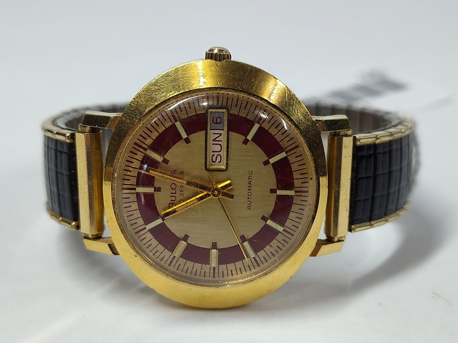 Bulova 23 Jewel Automatic Day-Date Watch, 1972: A men's wristwatch by Bulova, manufactured circa 1972 as indicated by the N2 date code on the case back. The timepiece features a round case with a gold electroplated bezel and a stainless steel case 