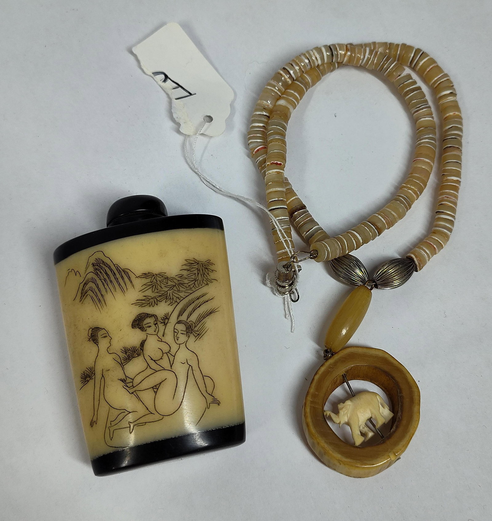 Chinese Erotic Snuff Bottle & Elephant Necklace: This lot features two East Asian decorative objects. The first is a snuff bottle with engraved erotic scenes in the shunga style. The bottle is fashioned from a light-colored material with