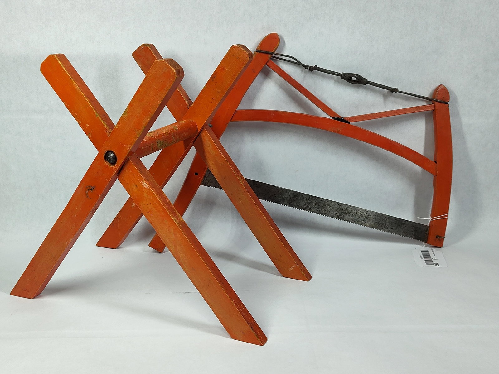 Pair Orange Wood Frame Saw & Folding Sawbuck: This set consists of matching traditional woodcutting tools, including a frame saw and a folding sawbuck, both constructed from wood and finished in a bright orange paint. The frame saw, commonly