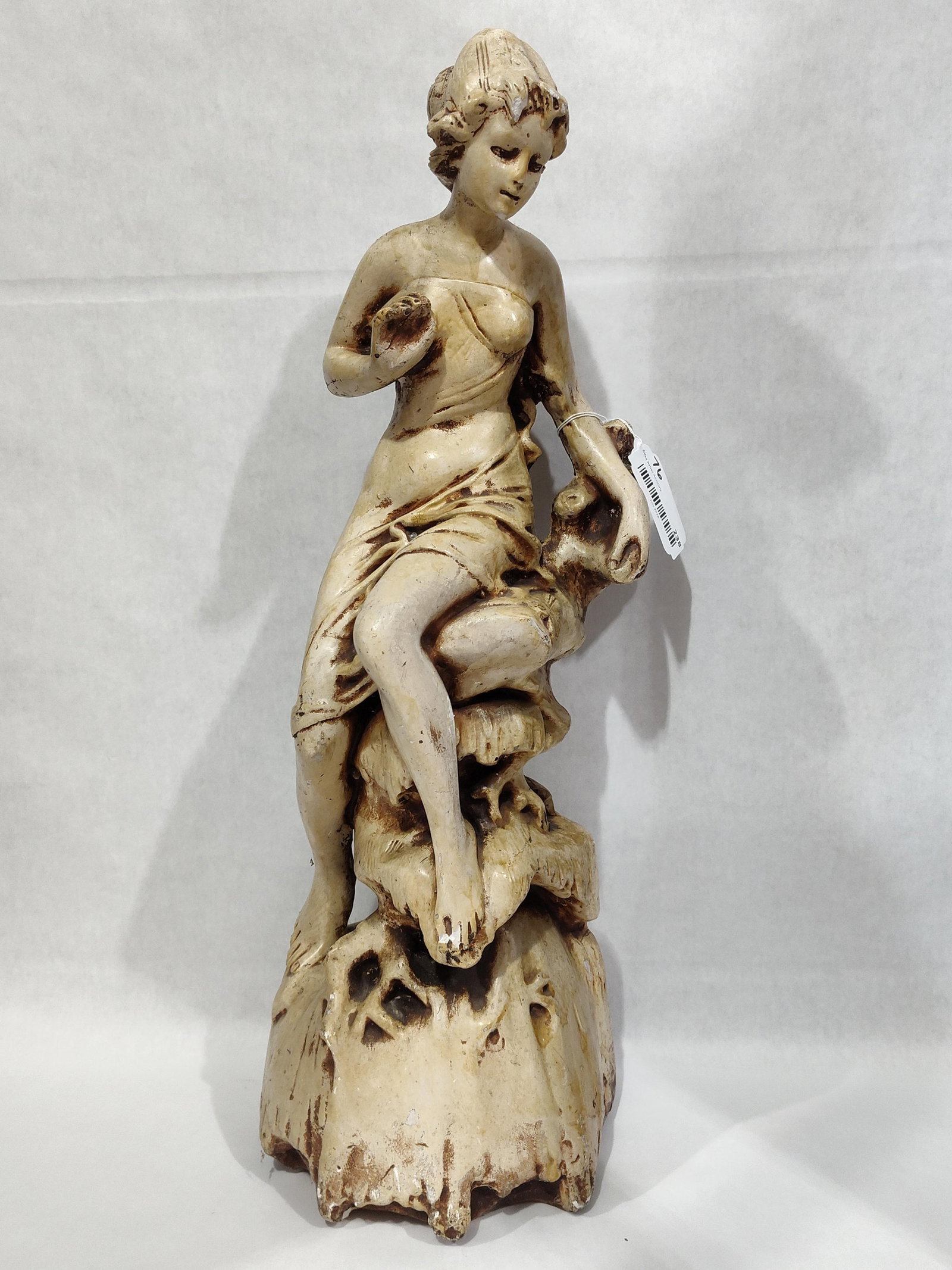 Cast Composition Classical Seated Female Figurine: A decorative cast composition sculpture depicting a partially draped female figure in a seated, contemplative posture. The figure is positioned upon a naturalistic, rock-like base. The piece is