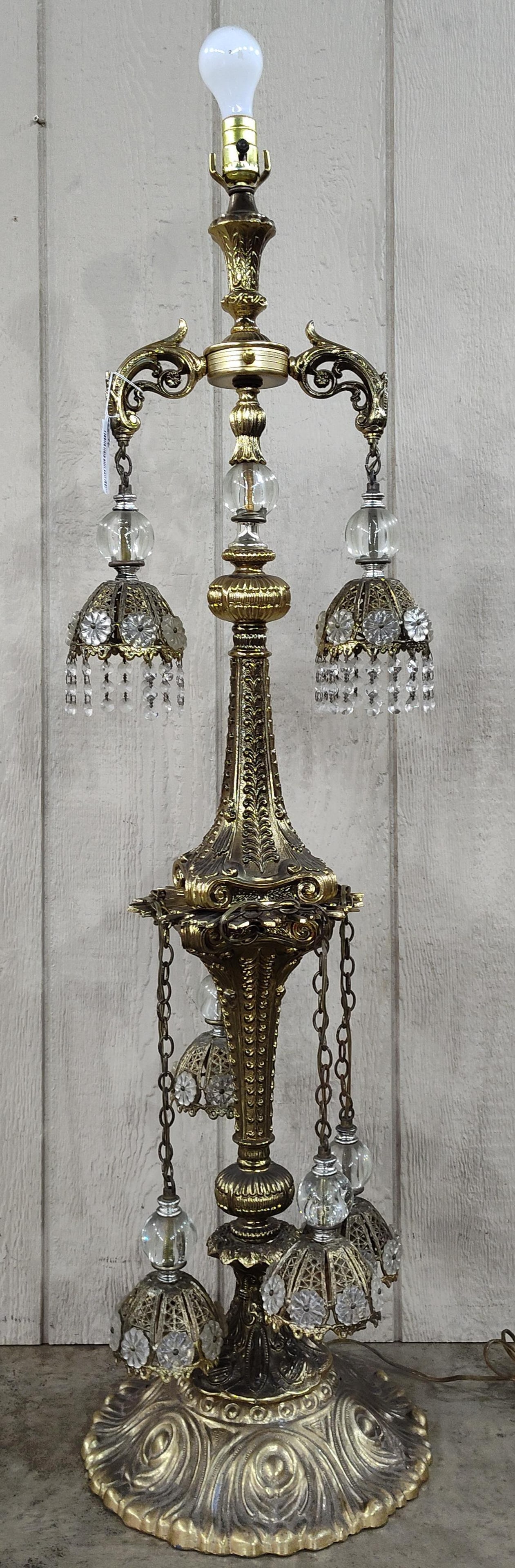 Attr. Loevsky & Loevsky 6-Light Filigree Lamp: 54 inches. This ornate six-light table lamp is crafted in the Hollywood Regency style and is attributed to the manufacturer Loevsky and Loevsky. The structure consists of a tiered cast metal frame