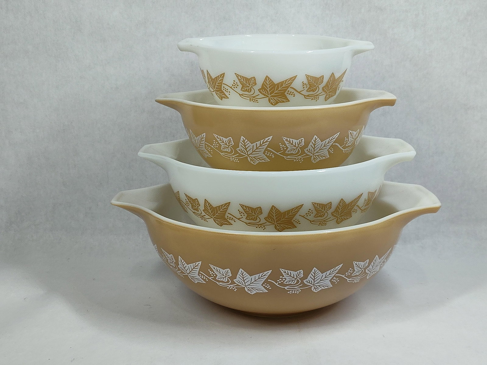 Pyrex Sandalwood Cinderella Nesting Mixing Bowls: This set of nesting mixing bowls is manufactured from opal glass, often referred to as milk glass, by Pyrex. The collection features the Sandalwood pattern, which consists of a trailing ivy vine motif