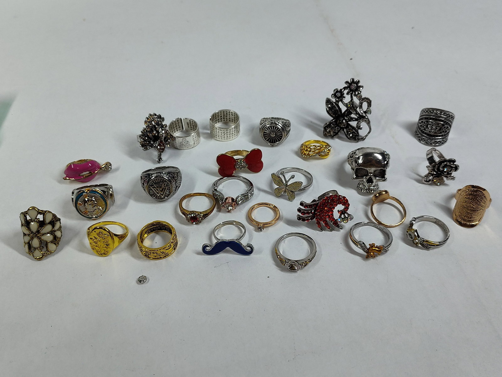 26 Novelty, Signet & Cocktail Rings: An assortment of twenty-six rings in various designs, including novelty, signet, and decorative cocktail styles. The collection features a mix of silver-tone, gold-tone, and rose-gold-tone base