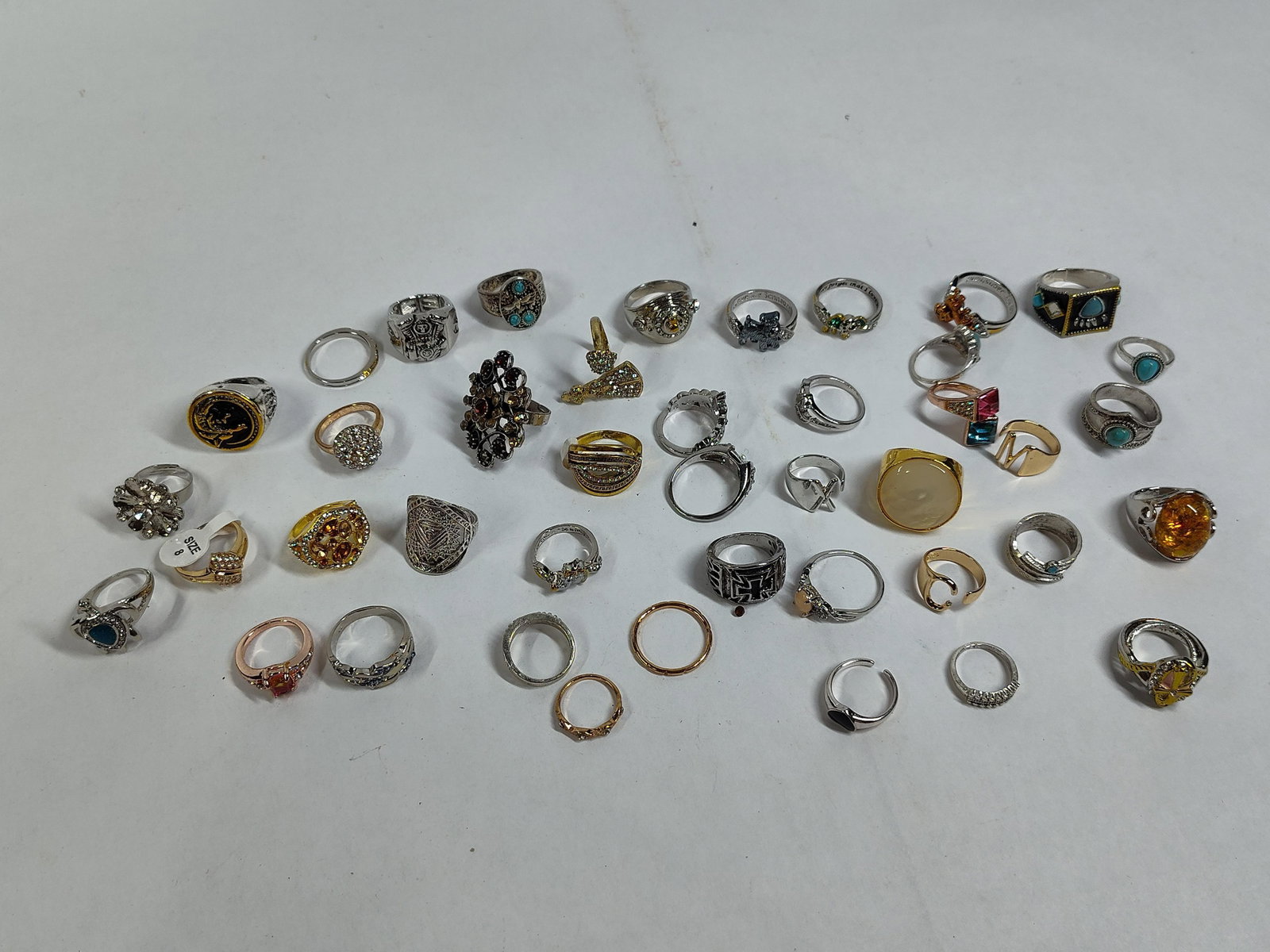 An Assortment of Fashion and Costume Jewelry Rings: This lot comprises a collection of fashion and costume jewelry rings in a diverse range of styles. The group includes cocktail rings, stackable bands, signet-style rings, and several themed pieces. No
