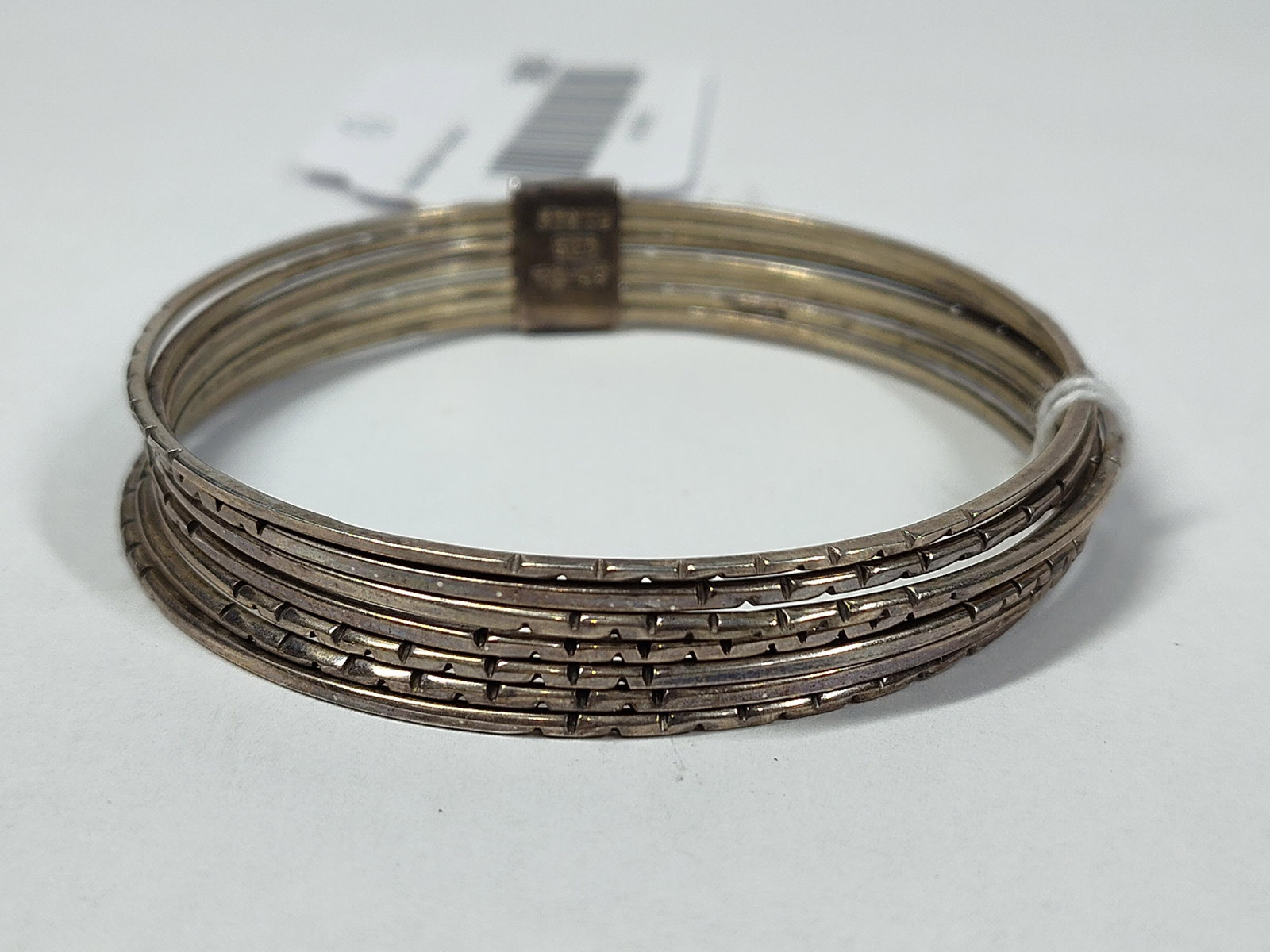 Taxco Mexican Str. Seven-Strand Semanario Bracelet: A sterling silver multi-strand bangle bracelet of Mexican origin. This piece is a semanario style bracelet, featuring seven individual thin, textured wire strands held together by a single