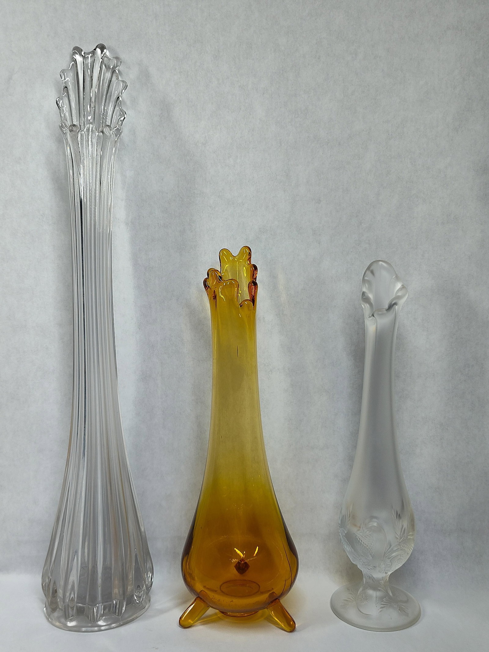 3 American Glass Vases w/ Fenton Satin & Swung: 10.5 x 17. This lot contains three pieces of American decorative glass from the mid-to-late 20th century. Included is a tall clear glass swung vase featuring a 12-finger pulled rim and a vertically