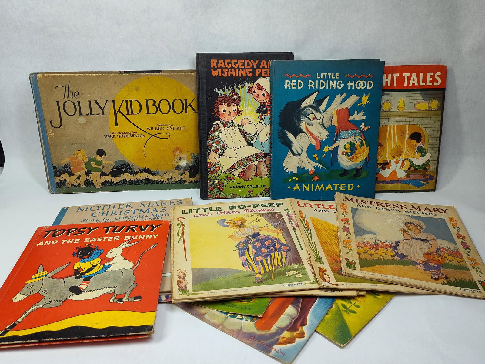 Children's Books & Linenette Booklets, 20th C: This collection of children's literature includes a variety of hardcover books, a spiral-bound mechanical book, and several softcover booklets. Featured titles include The Jolly Kid Book with verses