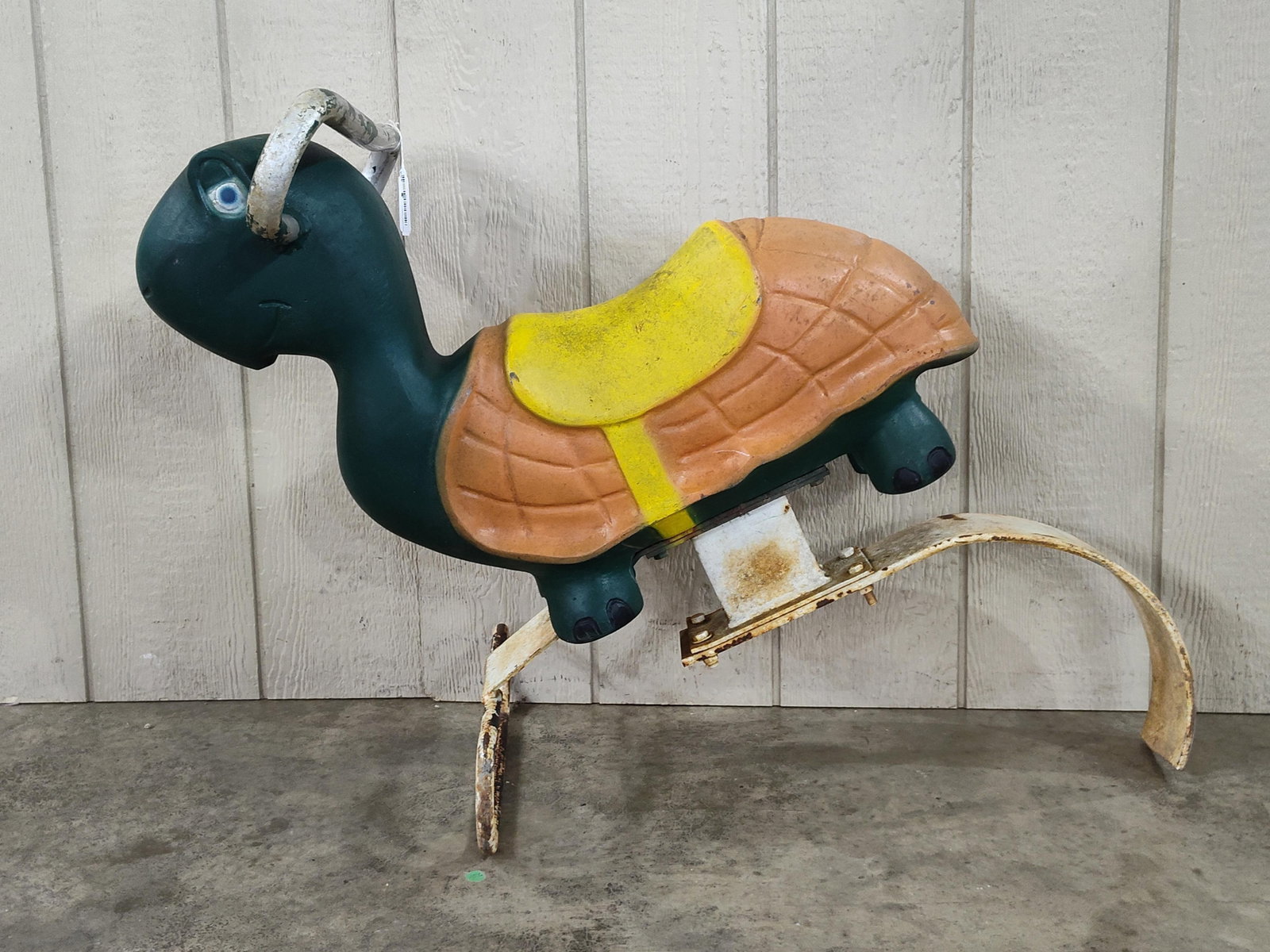 Playworld Systems Plastic Turtle Spring Rider: This is a playground spring rider manufactured by Playworld Systems, designed in the form of a turtle. The body is constructed from molded polyethylene plastic featuring a dark green torso and limbs,