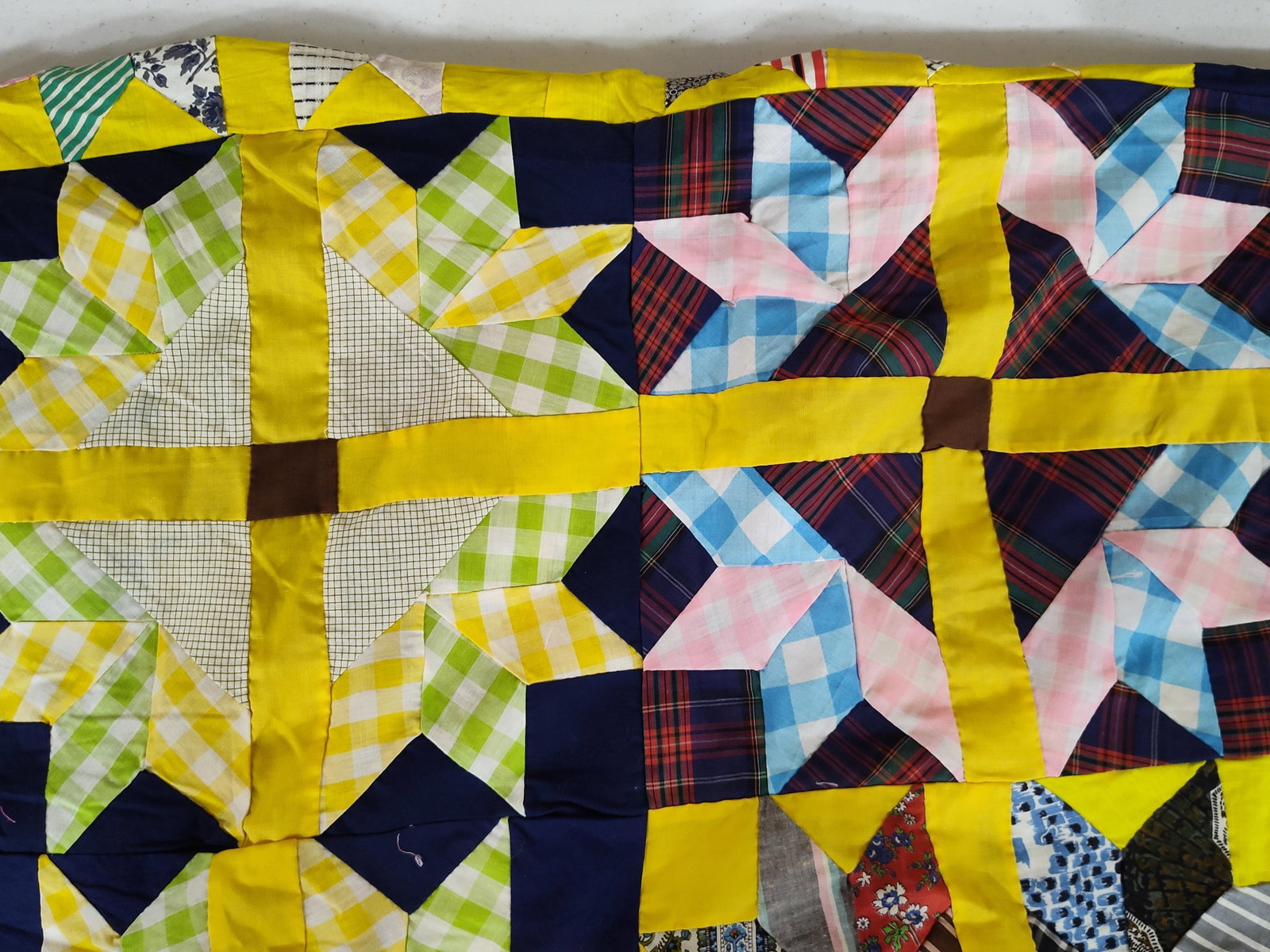 Mid-20th C. Hand-Quilted 8-Point Star Scrap Quilt: This vintage handmade scrap quilt features a repeating eight-point star pattern, a variant of the LeMoyne Star. The piece is hand-pieced and hand-quilted with visible white running stitches. The quilt