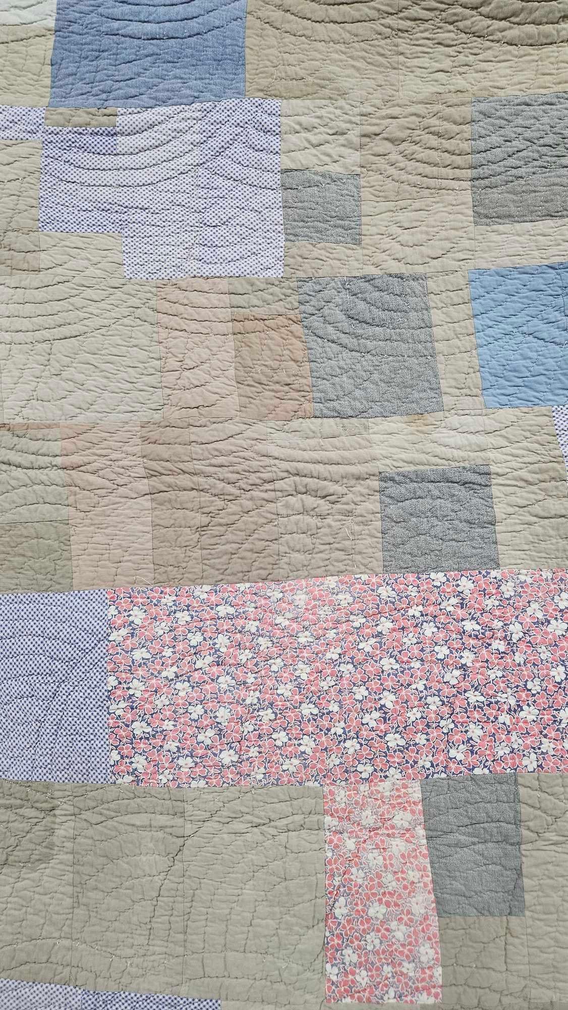 Mid-20th C. American Patchwork Utility Quilt: This American utility quilt features an improvisational patchwork top composed of various rectangular and square cotton fabric blocks. The material palette includes solid-colored wovens in tan, light