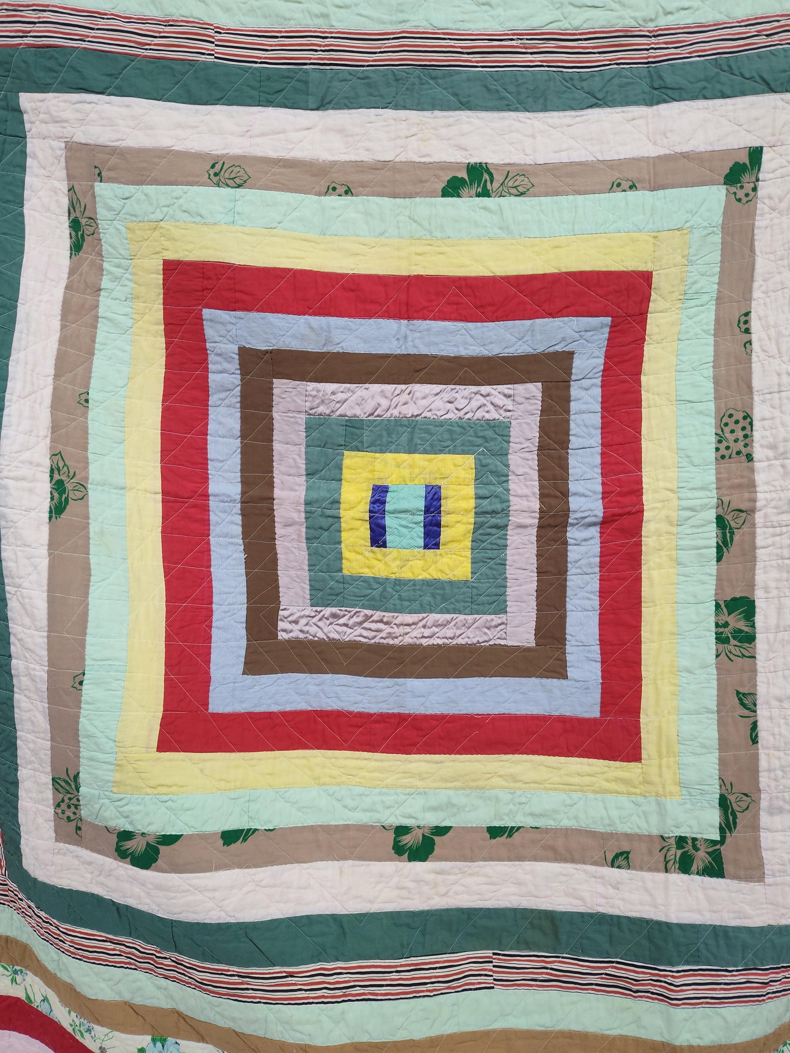 Mid-C. American Hand-Quilted Medallion Scrap Quilt: This vintage handmade pieced quilt is designed in a concentric square or medallion pattern, a style often associated with the utilitarian and improvisational quilting traditions of the American South.