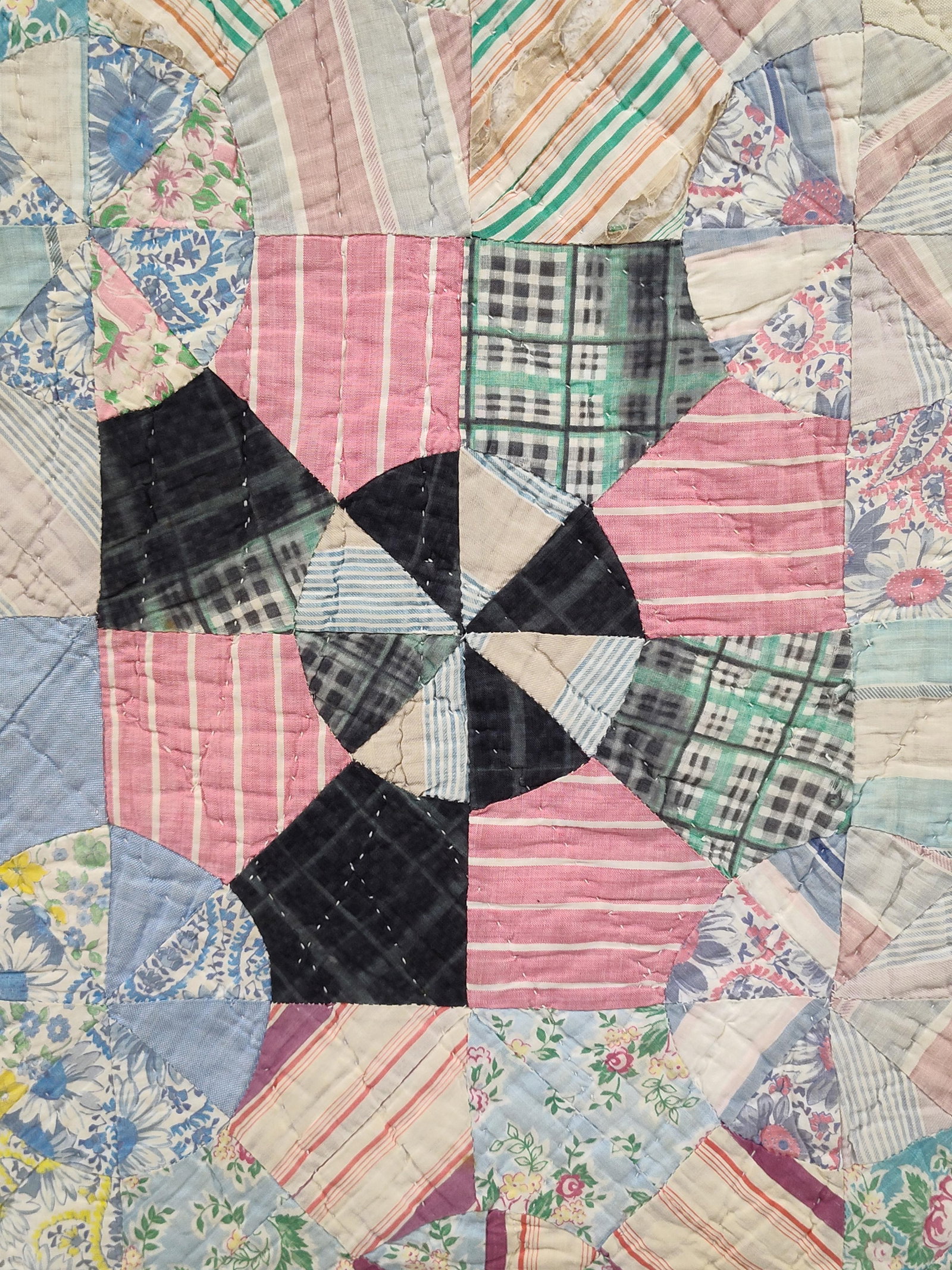 American Wagon Wheel Quilt w/ Seed Sack Backing: This is a mid-20th-century American bed quilt, hand-pieced and hand-quilted in a traditional Wagon Wheel or Kaleidoscope pattern. The quilt top is composed of various cotton fabrics including floral