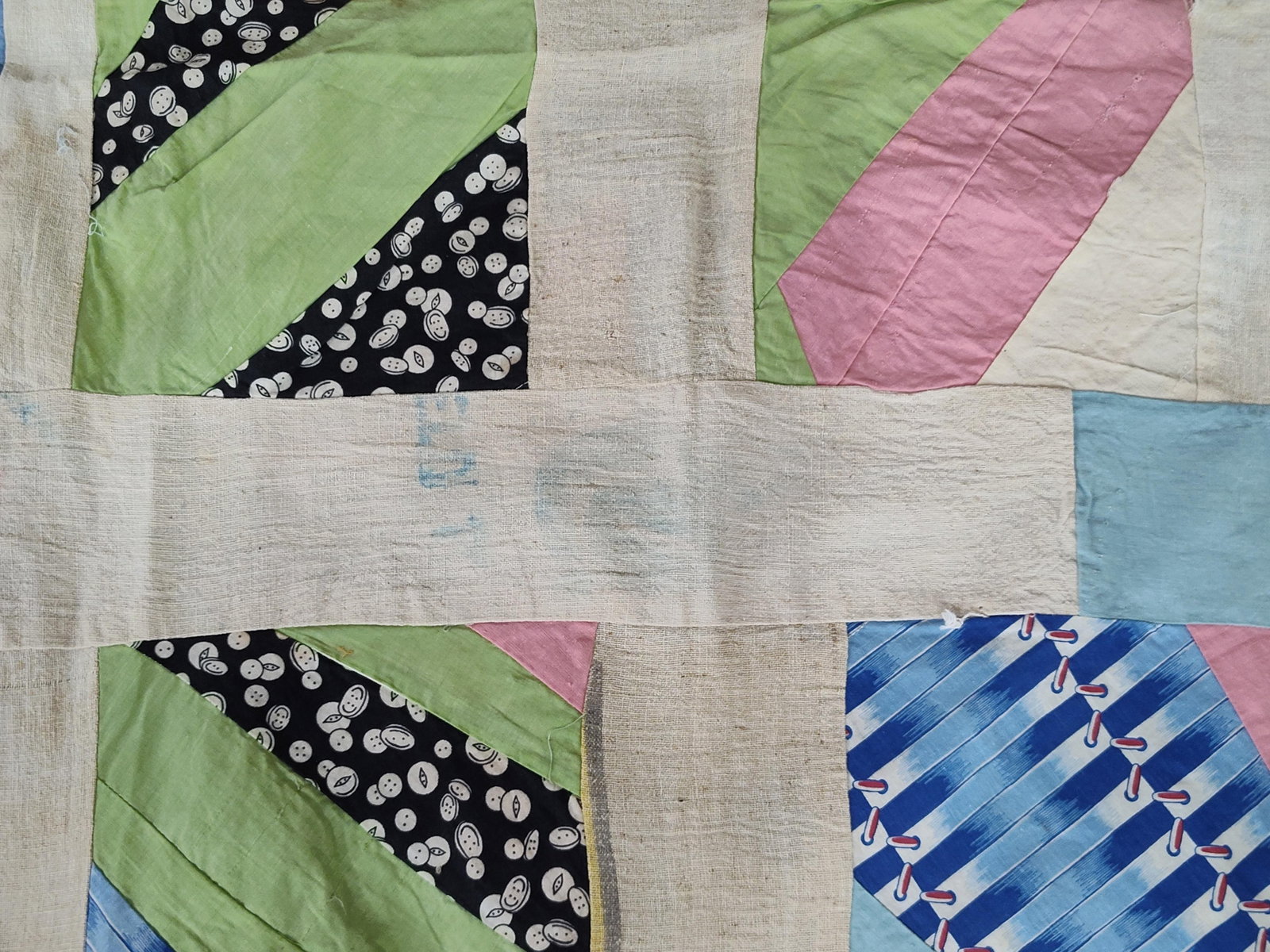 Mid-20th C. American String-Pieced Feed: This is a mid-20th-century American pieced quilt top constructed from various cotton print and solid fabrics. The piece features a grid of string-pieced or strip-pieced blocks, each composed of