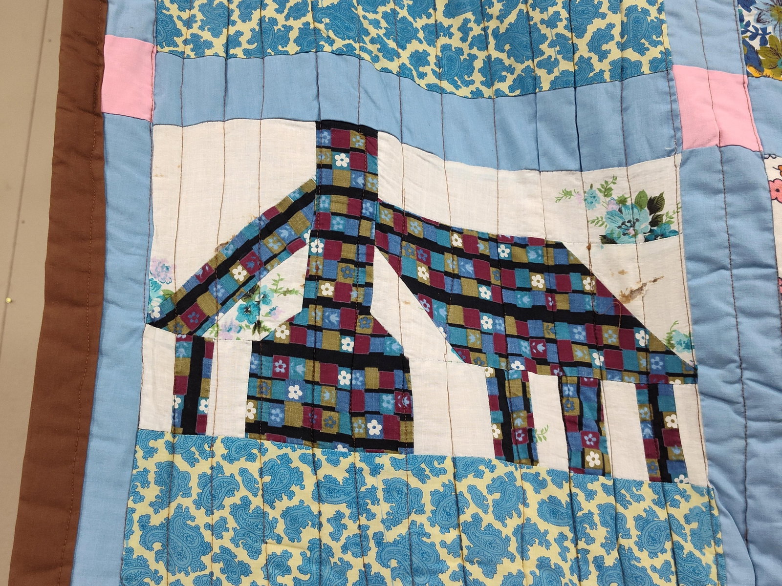 Schoolhouse Pattern Multi-Fabric Patchwork Quilt: This vintage American patchwork quilt features the traditional Schoolhouse pattern, consisting of 24 individual blocks arranged in a 4-by-6 grid. Each house motif is pieced from a variety of scrap fab
