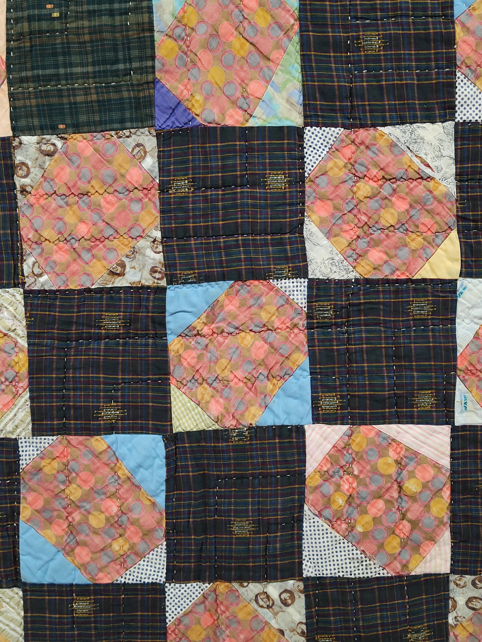 American Hand-Stitched Snowball Utility Quilt: This vintage American utility quilt features hand-pieced and hand-quilted construction. The front is designed with a grid of alternating patchwork blocks. One set of squares is composed of dark plaid 
