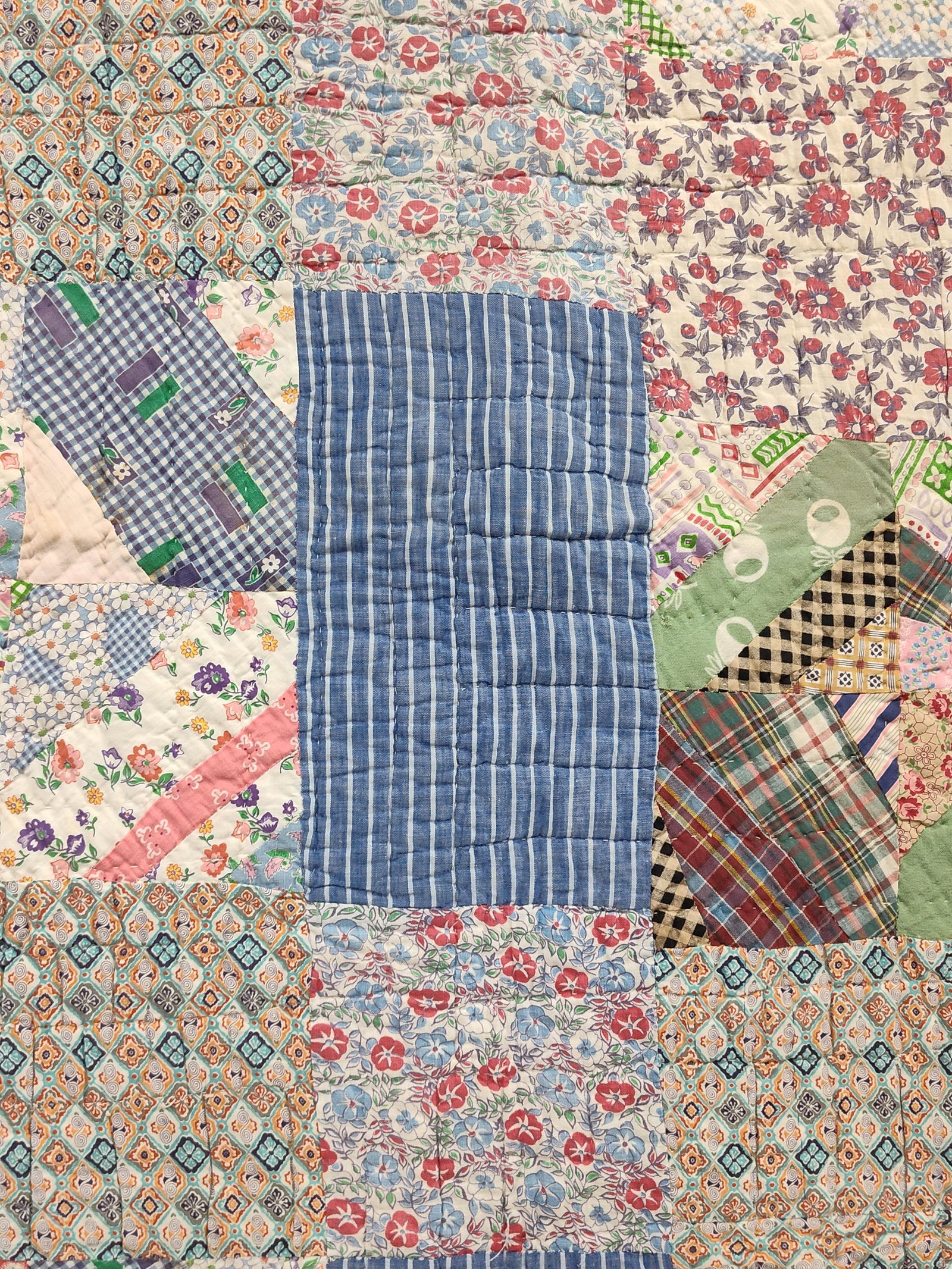 American Hand Quilted Patchwork Quilt, Grain Sack: A vintage American hand-quilted patchwork scrap quilt dating to the early-to-mid 20th century. The quilt top is constructed from an eclectic variety of cotton fabric scraps including ditsy florals,