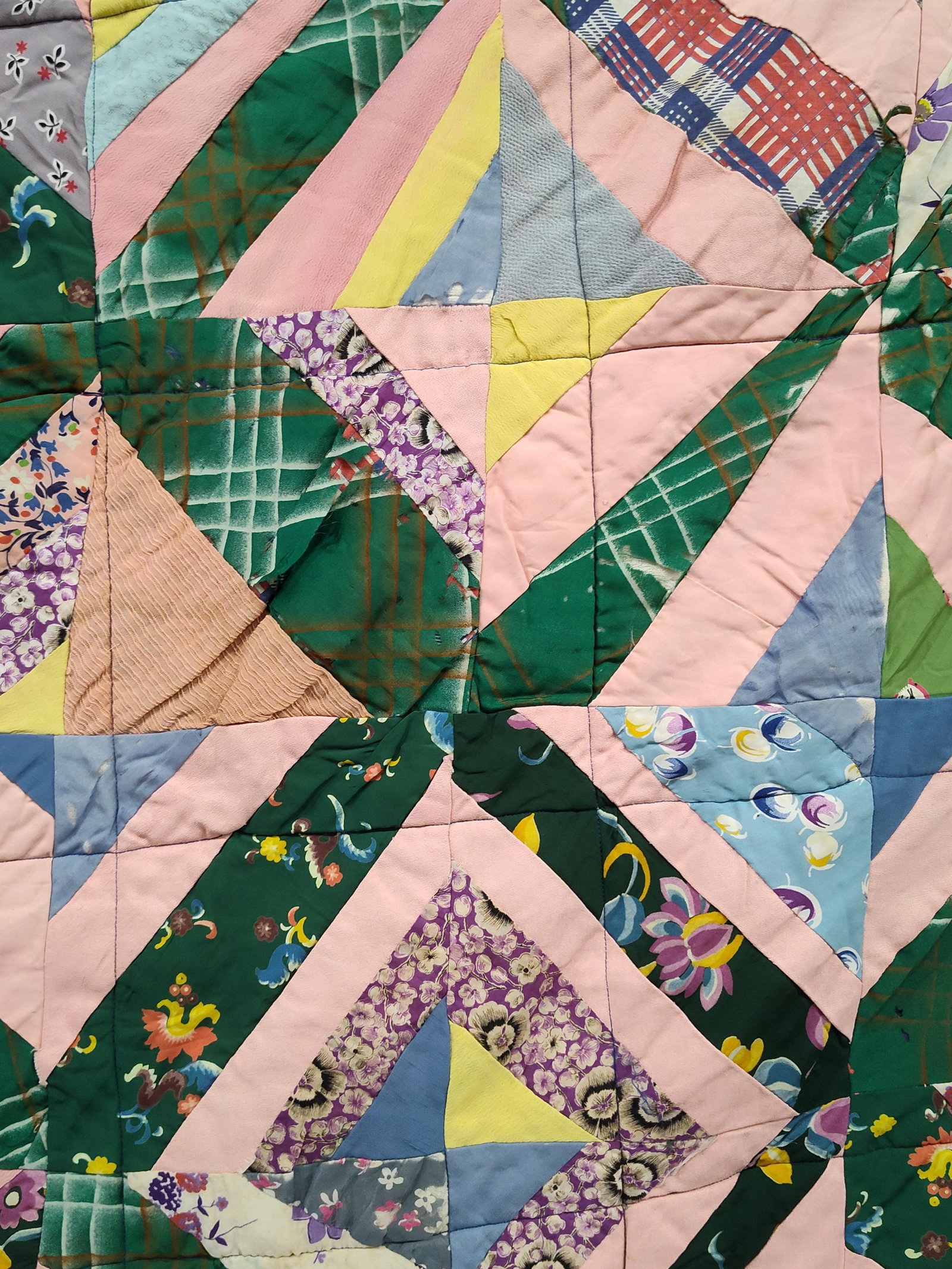 Mid-Century American Hand-Pieced Geometric String Quilt: This hand-pieced scrap quilt features a variation of a string star or string diamond pattern. The quilt top is constructed from square blocks divided into four quadrants, each filled with diagonal fab