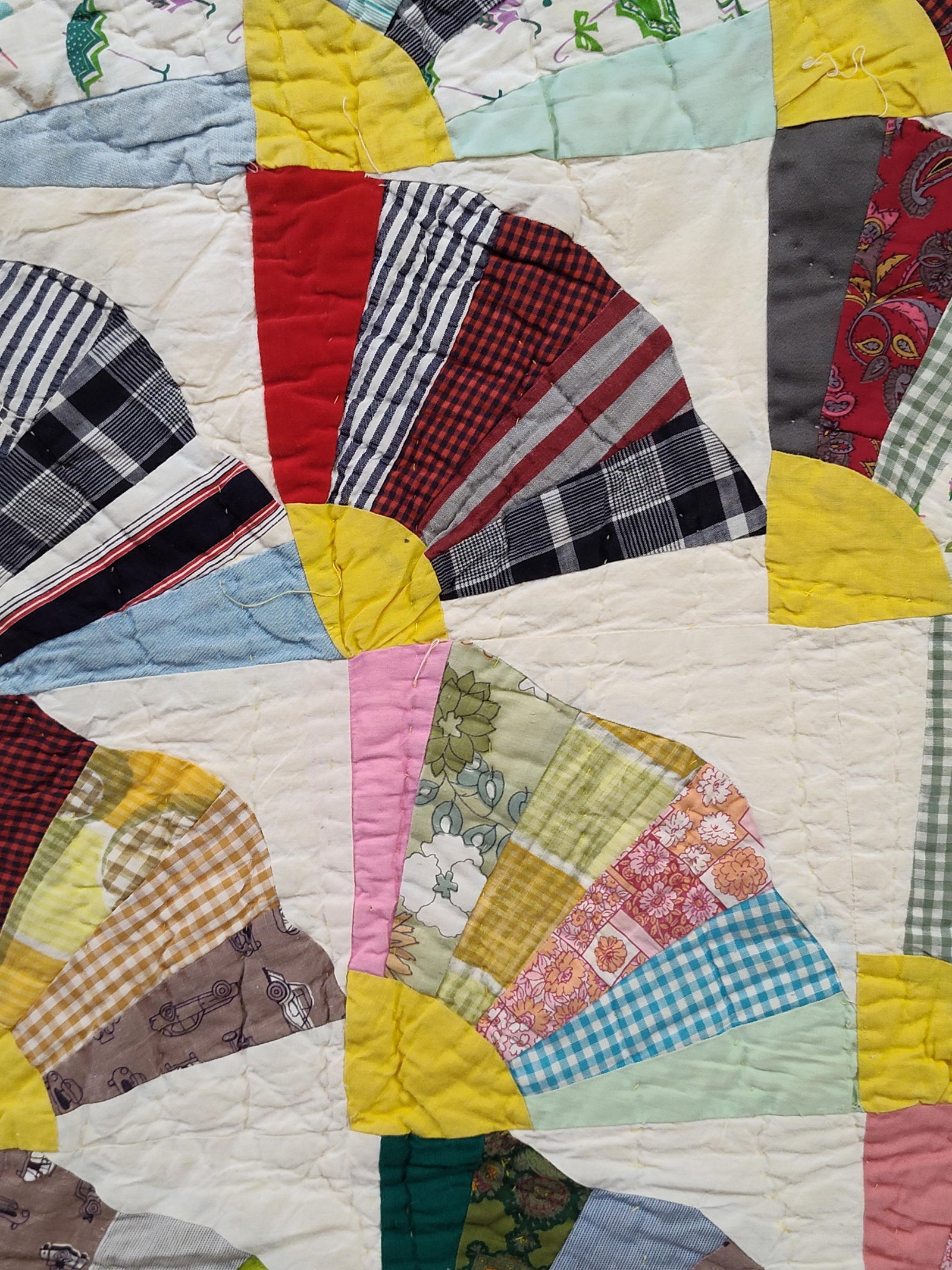 American Hand-Quilted Grandmother's Fan Quilt: This vintage American patchwork quilt features the traditional Grandmother's Fan pattern. The piece is composed of square blocks, each showcasing a fan motif made of radiating wedges in a diverse