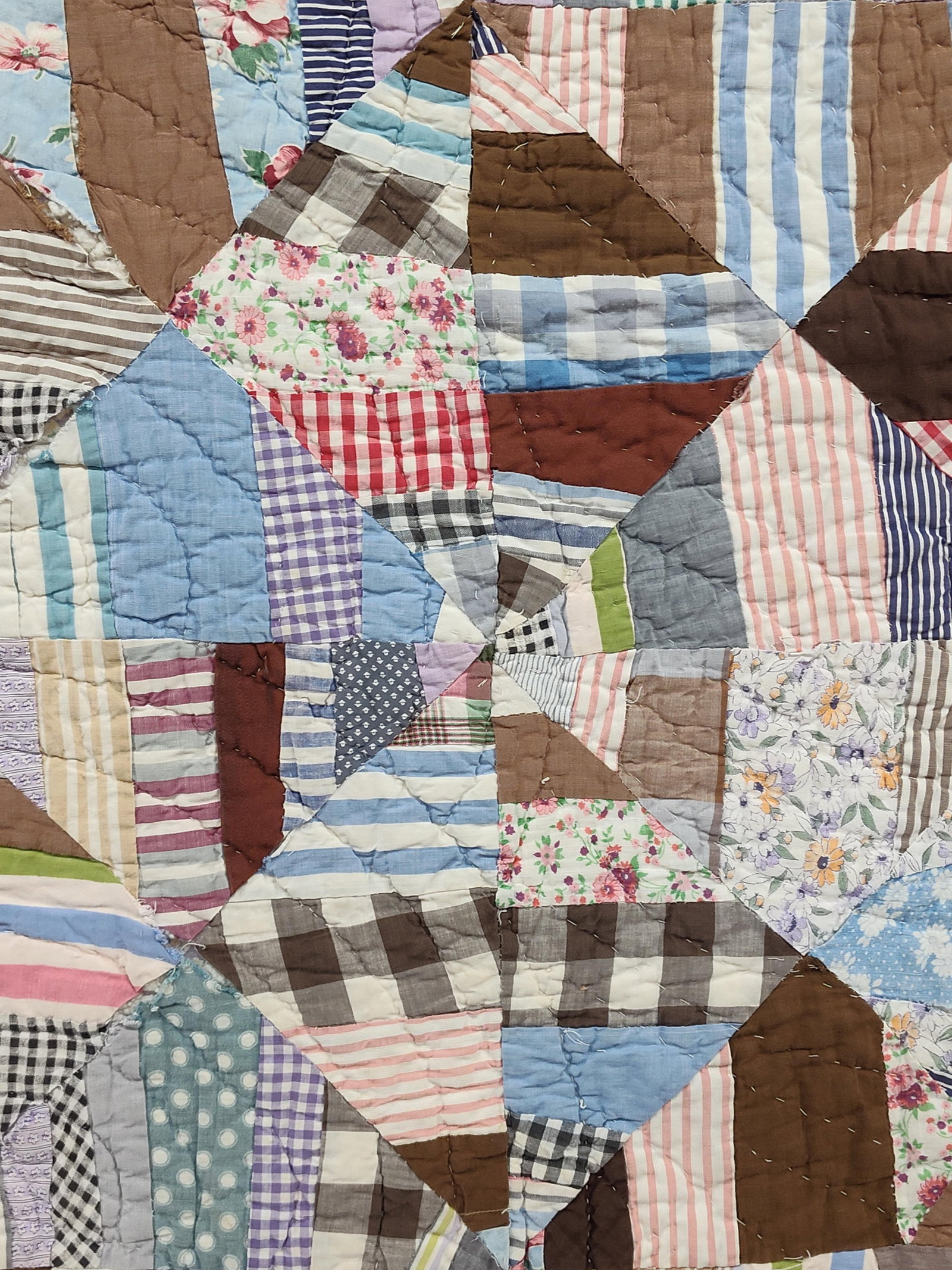 Hand-Quilted Patchwork Scrap String Pattern Quilt: This vintage pieced patchwork quilt is constructed in a string or spider web pattern, utilizing a wide variety of cotton scrap fabrics. The textiles include printed and woven cottons in various patter