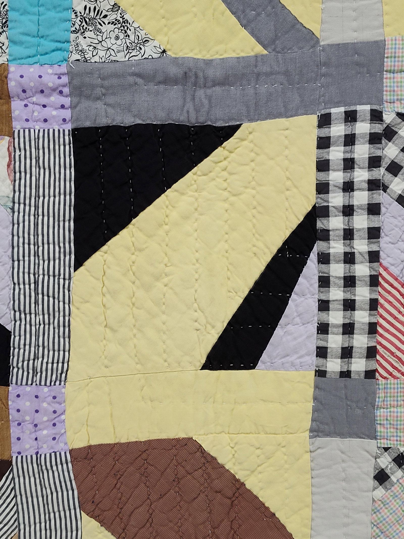 Hand-Pieced & Hand-Quilted Scrap String Quilt: A vintage handmade patchwork scrap quilt featuring a variation of a string quilt or diagonal-strip pattern. The quilt is composed of square blocks, each featuring diagonal fabric strips in an