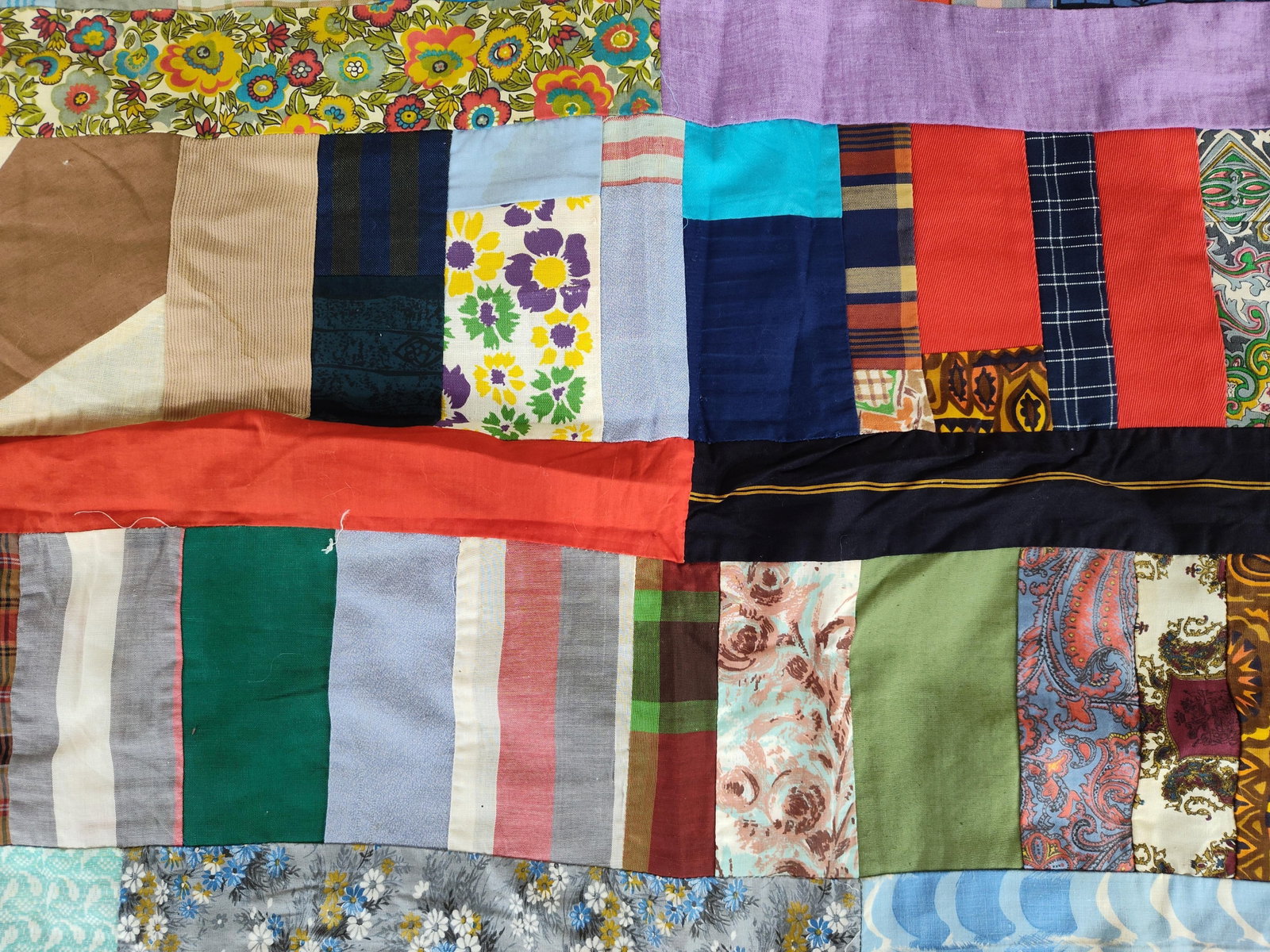 Mid-20th C. Strip-Pieced Patchwork Quilt Top: This is a mid-to-late 20th-century American patchwork quilt top constructed in a varied strip-pieced or string patchwork style. The unfinished top is composed of a diverse array of scrap textiles, inc
