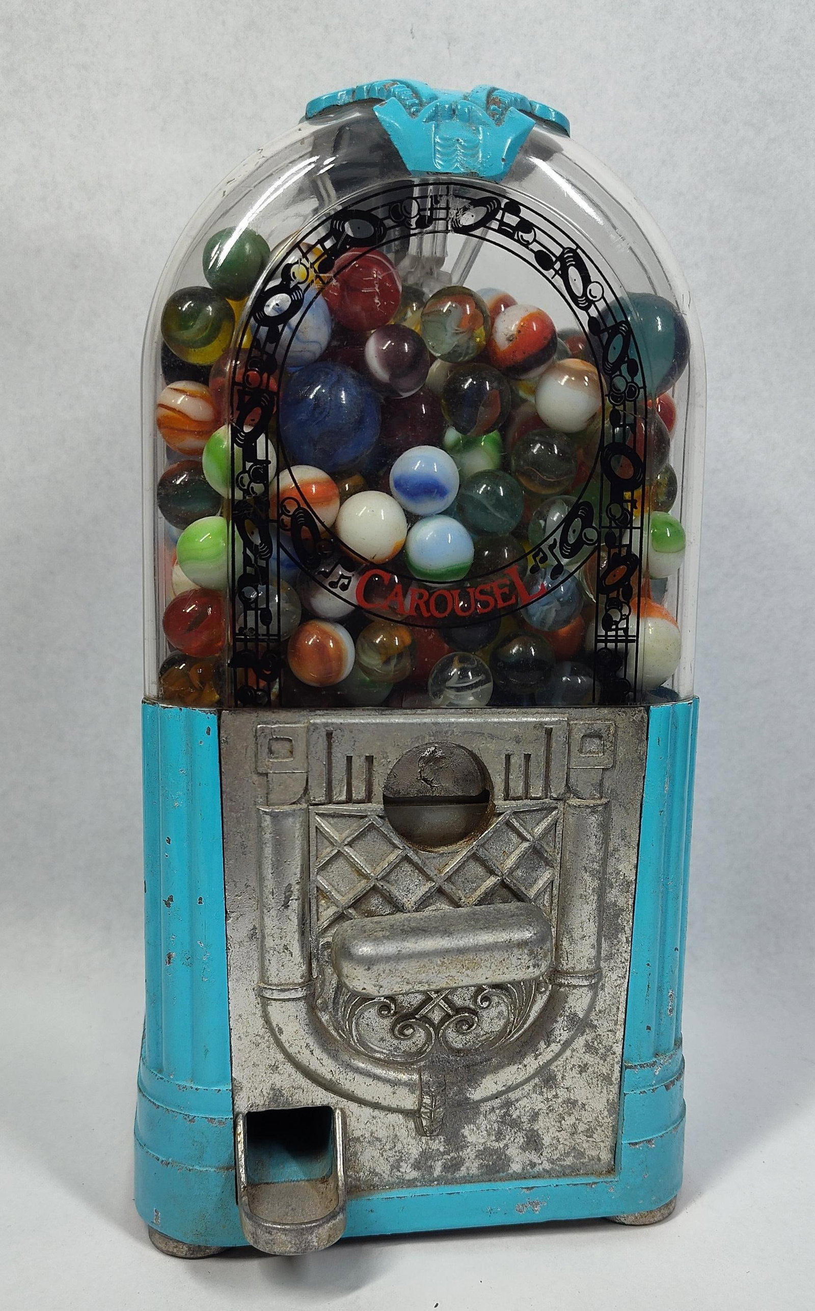 Carousel Jukebox Gumball/Marble Machine: This jukebox-styled vending machine was manufactured by Carousel Industries, Inc and measures 10.5x5x4. It features a blue painted die-cast metal base and housing, topped with a clear plastic dome.