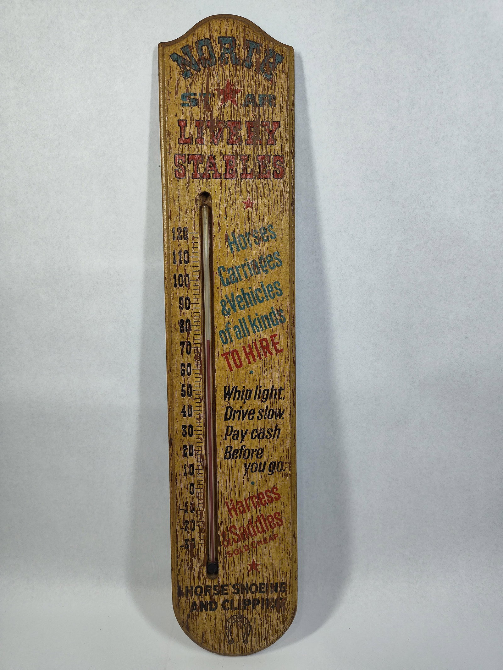North Star Livery Adv. Wood Thermometer: 5.25x26 wooden wall-hanging thermometer featuring advertising graphics for North Star Livery Stables. The piece is constructed from a solid wooden board with a rounded top and bottom profile. The