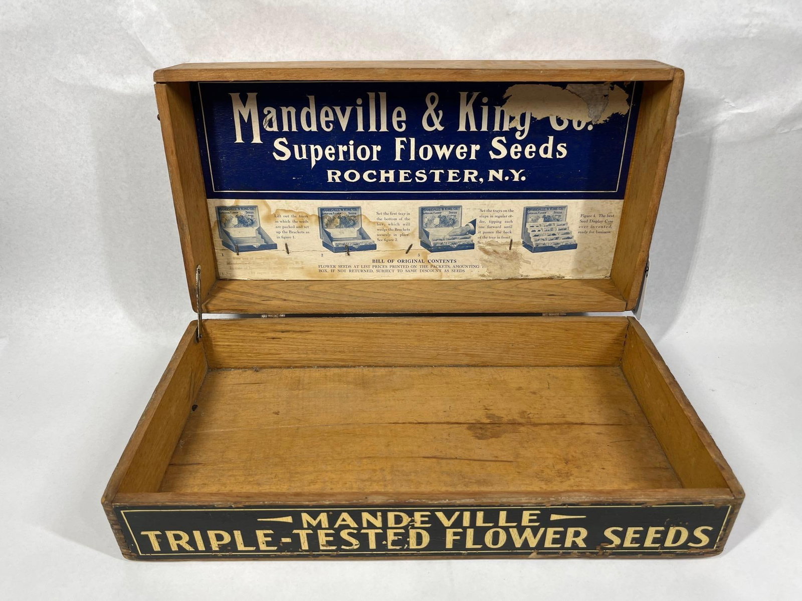 Mandeville & King Flower Seeds Wood Box: This is a wooden store counter display box produced for the Mandeville and King Company of Rochester, New York. The box is constructed from hardwood featuring finger-jointed corners. It contains