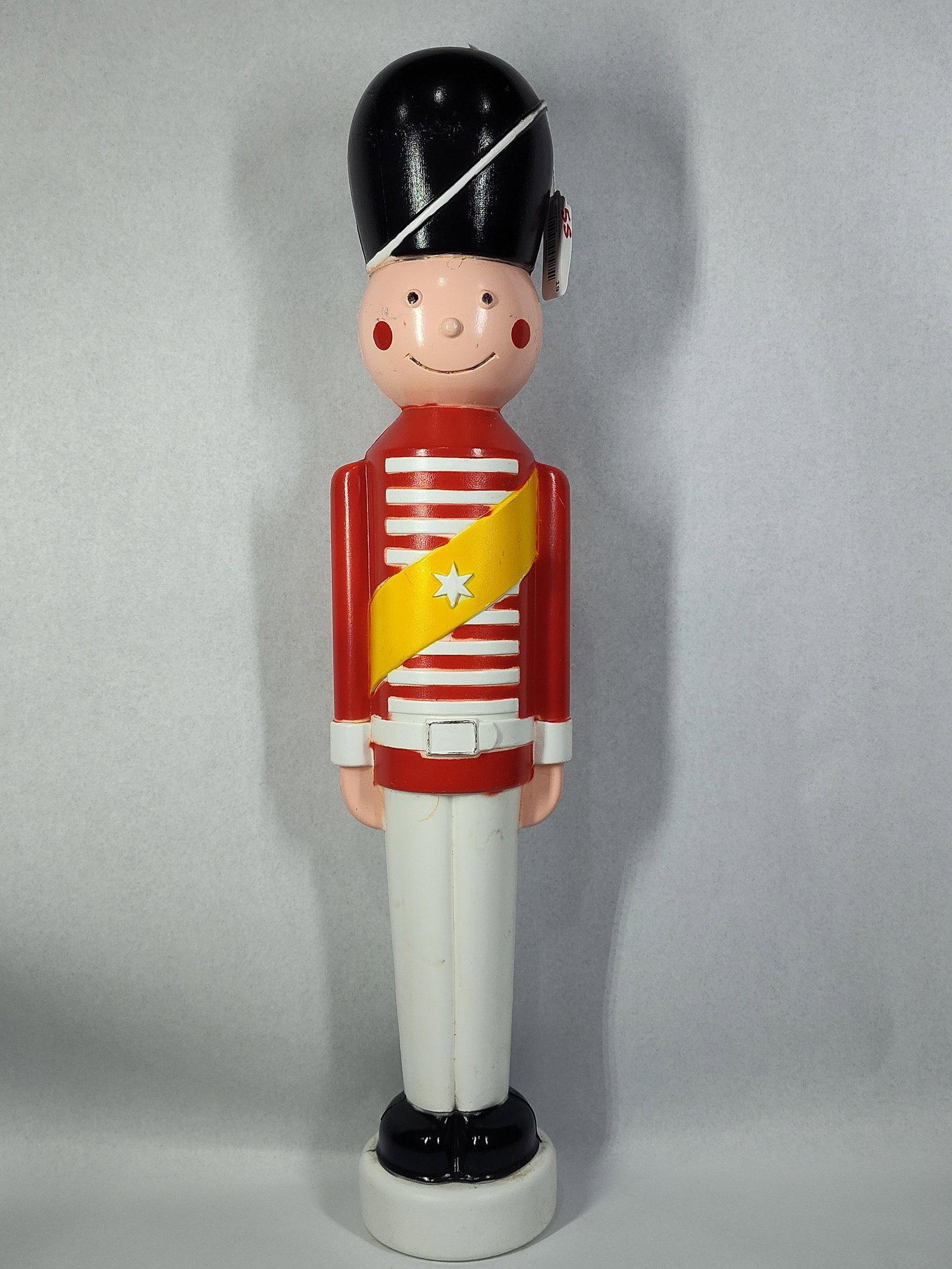 TPI Attrib. Lighted Blow Mold Soldier: 31in tall. This is a vintage holiday decoration featuring a toy soldier in a classic uniform. The figure is constructed of hollow, molded plastic through the blow mold process. The soldier is