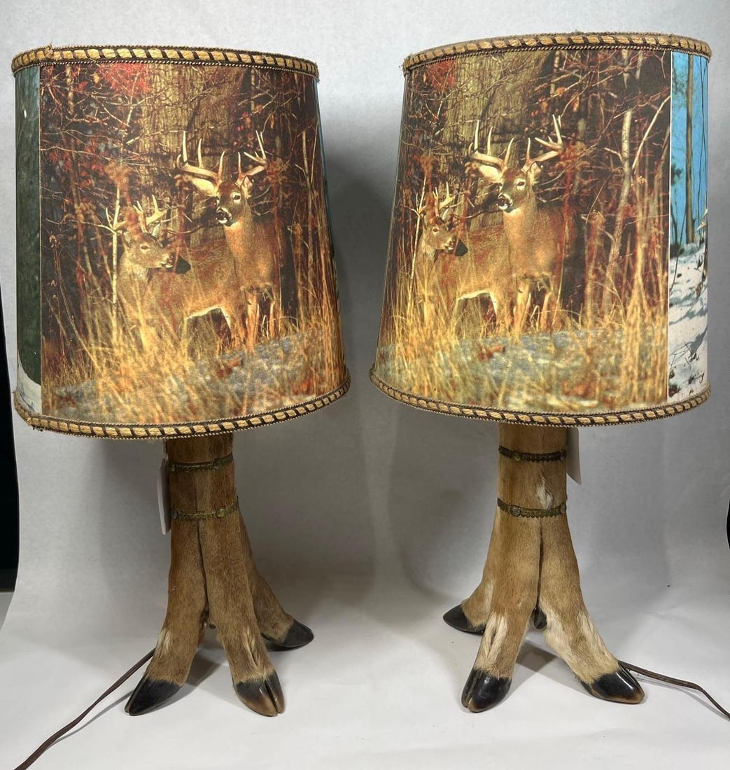 Pair Taxidermy Deer Hoof Tripod Lamps: 23in tall A pair of mid-20th-century table lamps in the rustic lodge style. Each lamp base is constructed using three taxidermy whitetail deer legs with hooves, arranged in a tripod configuration. The