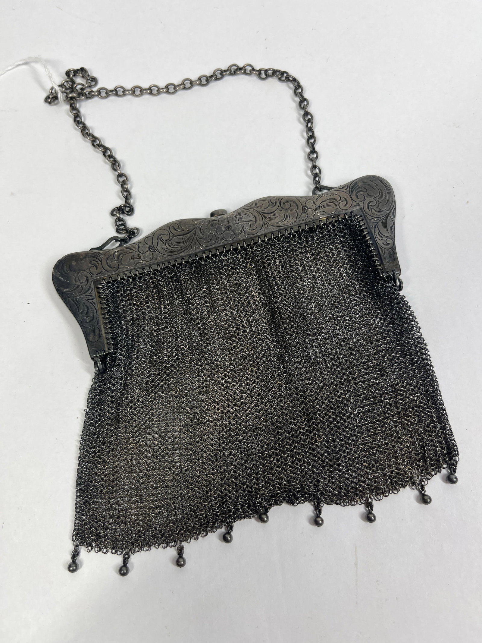 Edwardian Sterling Silver Mesh Evening Bag: An antique ring-mesh evening bag dating from the late 19th to early 20th century. The body is constructed of fine sterling silver ring mesh in a trapezoidal form, finished at the base with nine suspen