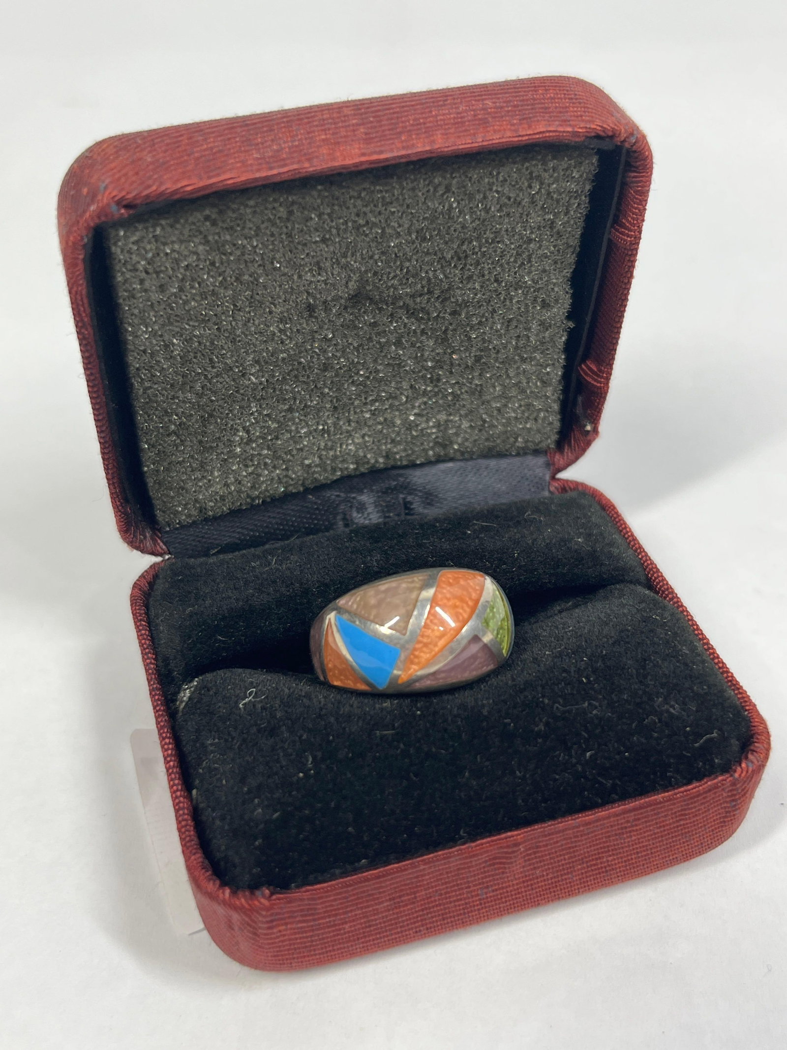 Kabana Sterling Multi-Color Shell Band Ring: This is a sterling silver band ring featuring a multi-color mosaic inlay by the manufacturer Kabana. The ring is designed as a wide, tapered band with a high-domed profile. The upper portion displays