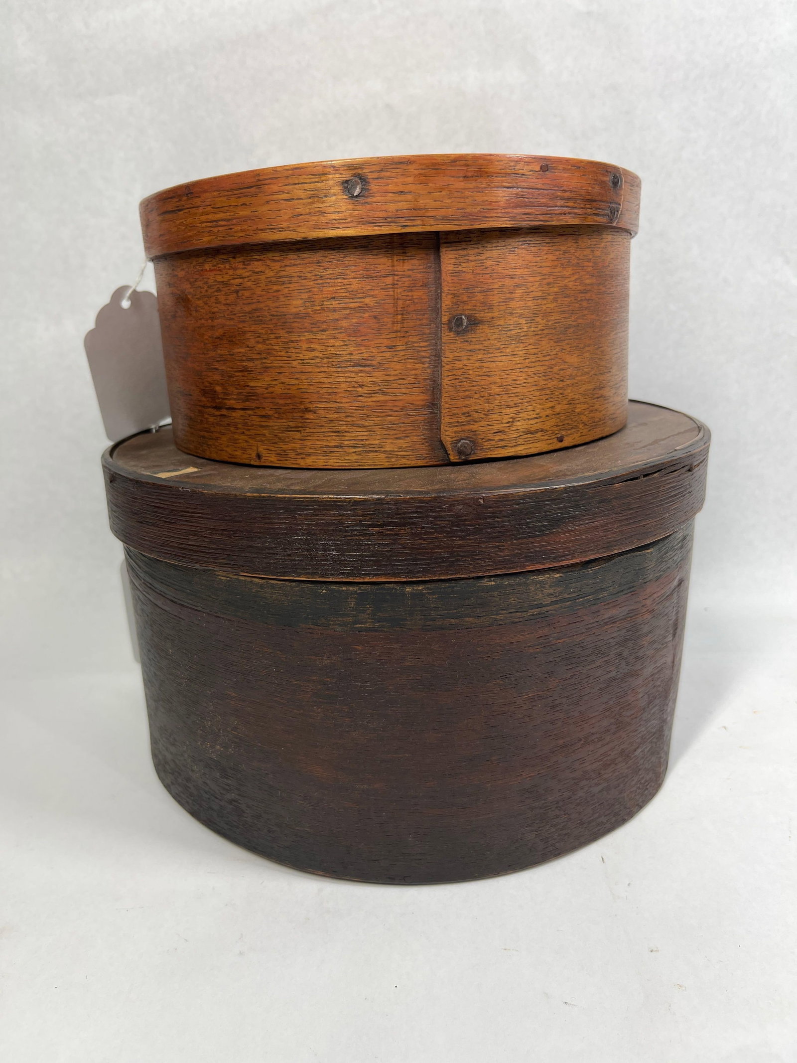 Pair American Bentwood Pantry Boxes: 7.5x9.5 A pair of antique circular bentwood pantry boxes featuring traditional lap-joint construction. These containers are crafted from thin, pliable wood strips bent into shape and secured at the ov