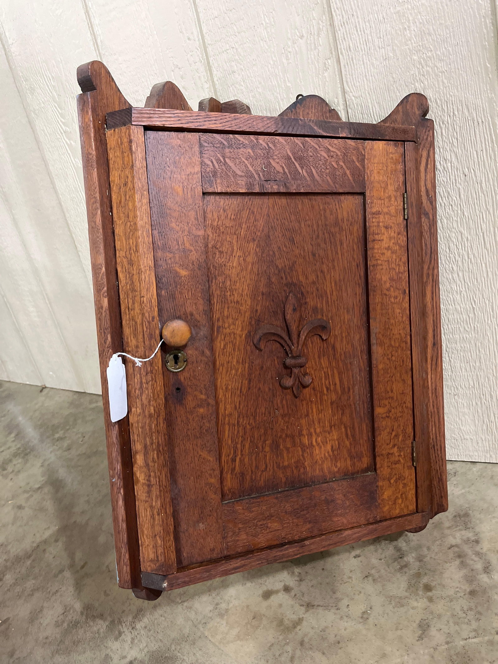 American Oak Hanging Corner Cupboard: 27x19 A wall-hanging corner cupboard crafted from quartersawn oak, exhibiting prominent medullary ray flakes throughout the frame and door. The single door features a recessed panel with an applied
