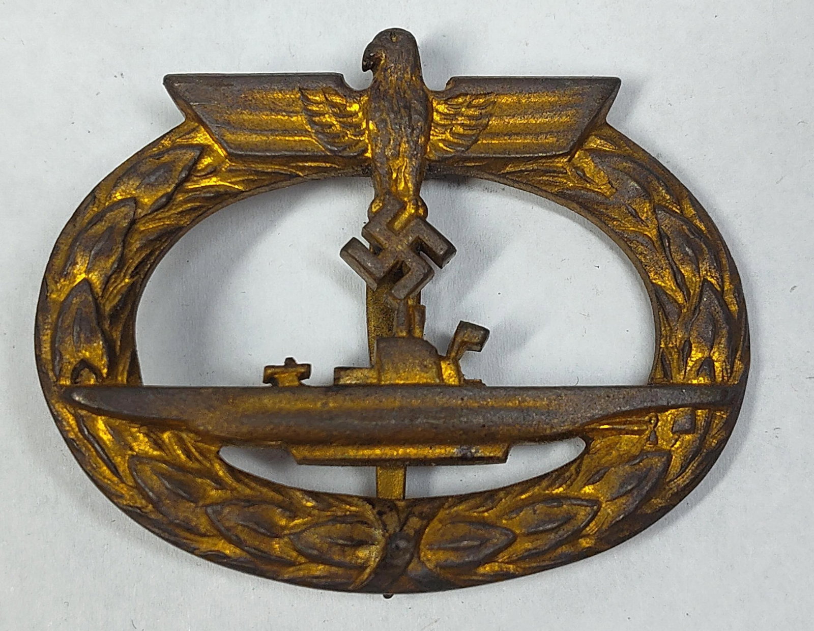 WWII German Kriegsmarine U-Boat War Badge by Schwerin Berlin: A WWII German Kriegsmarine U-boat War Badge (U-Boot-Kriegsabzeichen) produced by the manufacturer Schwerin & Sohn, Berlin. The badge is die-struck from a base metal alloy, likely tombak, and origi