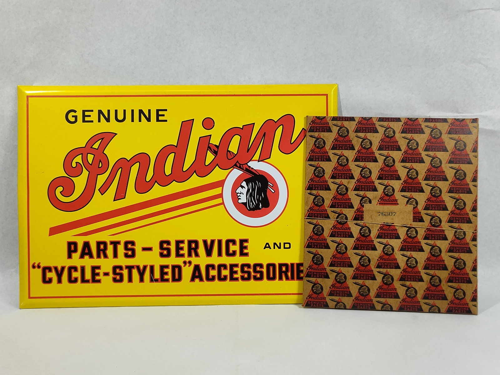 Indian Motorcycle Tin Sign & Gasket Kit: 13.5x9.5 sign This lot features two mid-20th-century items from the Indian Motorcycle Company, including a vintage advertising sign and a New Old Stock (NOS) gasket kit. The sign is a lithographed tin