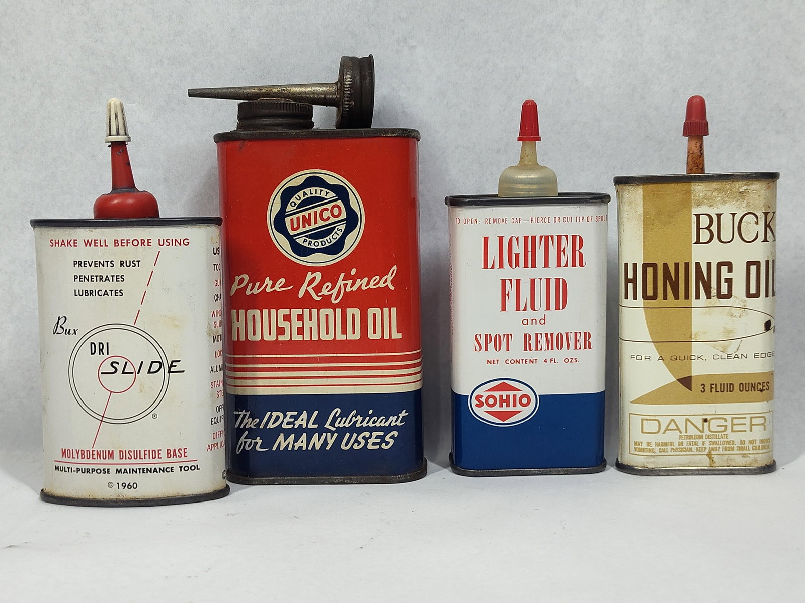 Set Tin Lubricant & Chemical Cans: An assortment of mid-20th-century lithographed tin containers for various household and automotive chemicals. This group includes a Dri-Slide multi-purpose maintenance tool can featuring a Molybdenum 