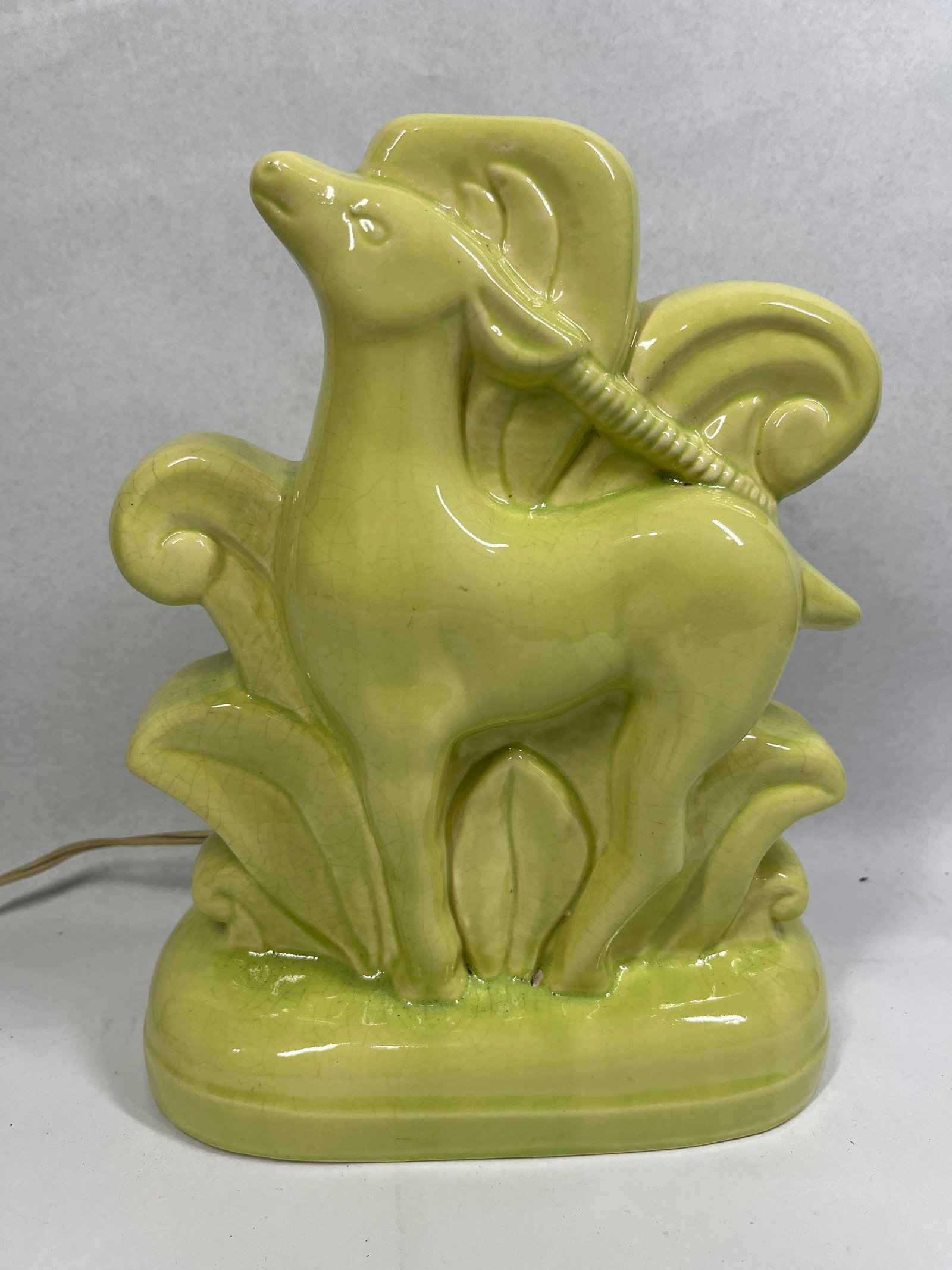 Mid-Century Chartreuse Gazelle TV Lamp: 9x11 A mid-century modern figural ceramic lamp, commonly referred to as a TV lamp, designed to provide ambient backlighting. The lamp features a stylized gazelle or deer positioned in front of large,