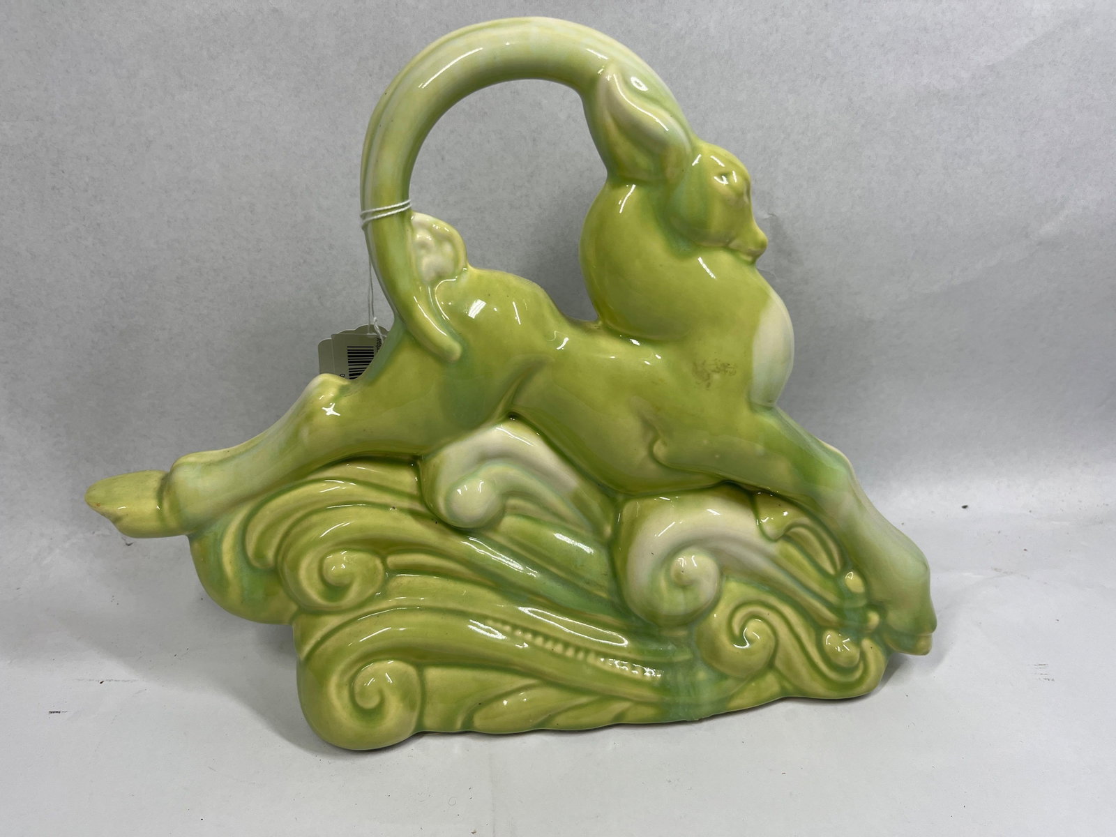 Haeger Style Ceramic Gazelle TV Lamp: 14x10 A mid-century modern ceramic TV lamp and planter combination, featuring a stylized leaping gazelle or deer figure mounted atop a base of swirling, wave-like scrollwork. The object is