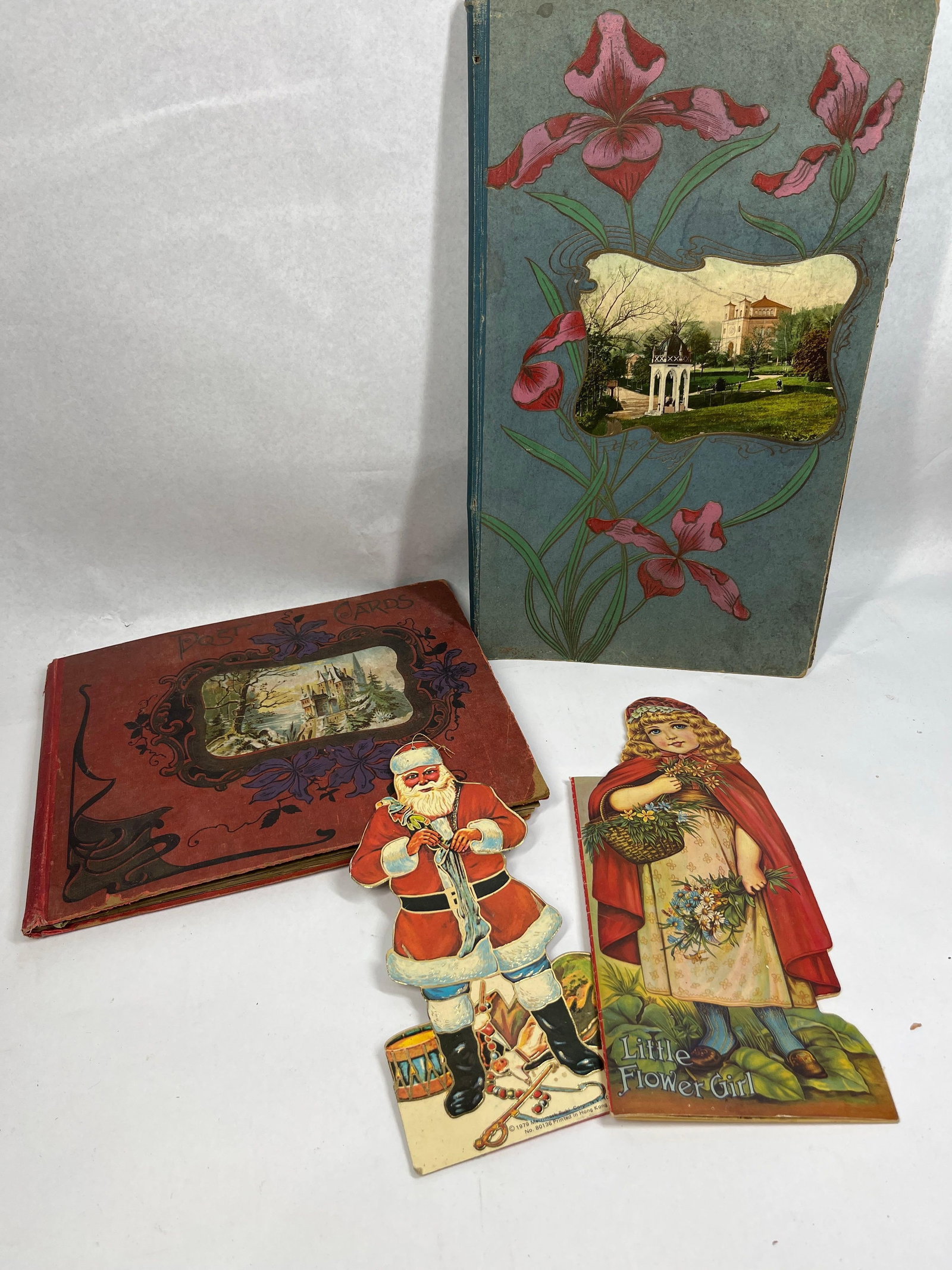 Merrimack Santa & Postcard Albums: This collection of paper collectibles consists of two albums and two large die-cut pieces. The first item is a cloth-bound postcard album titled Post Cards on a red cover with Art Nouveau style gilt