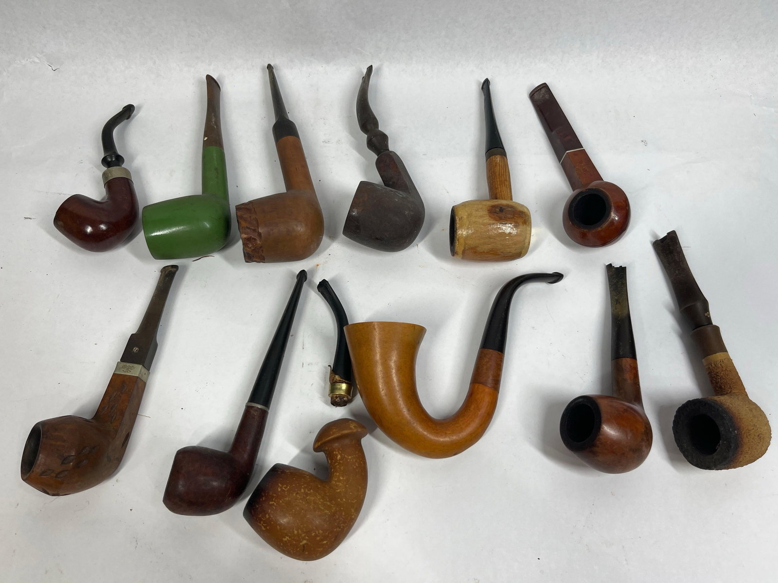 Dr. Grabow & Medico Tobacco Pipes: An assortment of vintage estate tobacco pipes in various traditional silhouettes, including bent, straight, and Oom Paul shapes. The group features bowls primarily constructed of briar wood with vulca