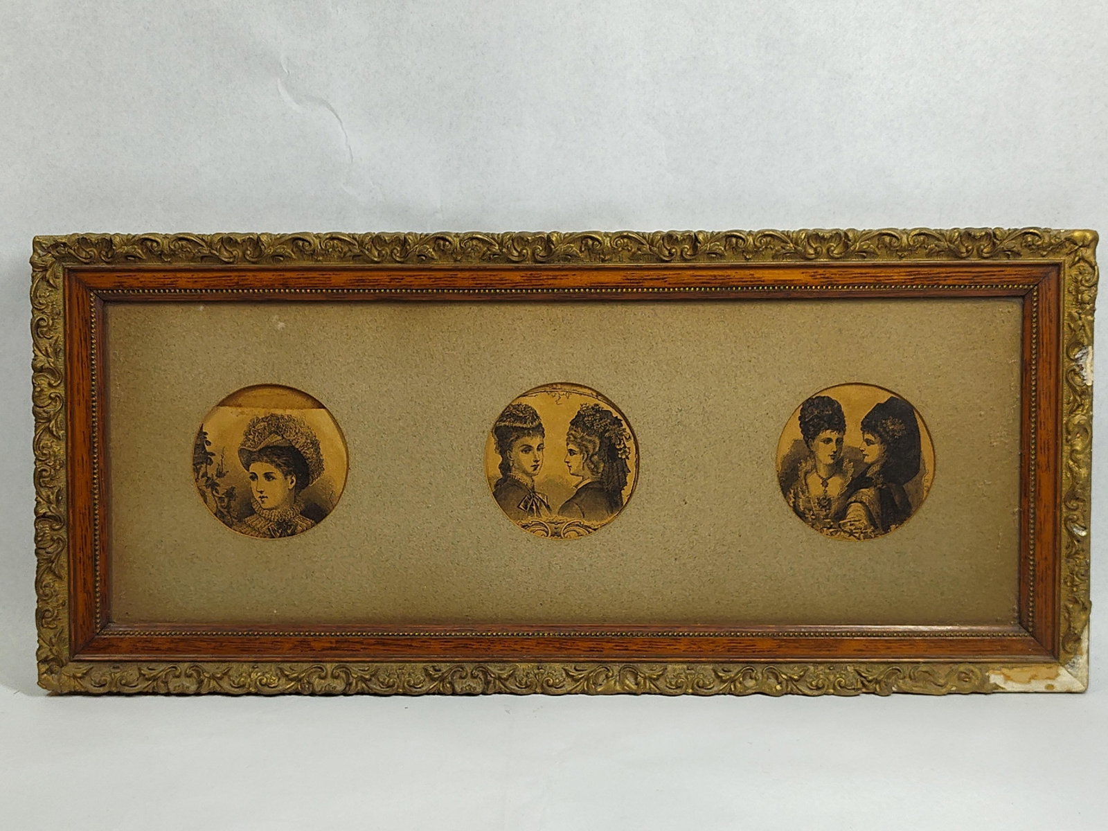 Trio of Victorian Fashion Engravings: 23x10 This lot features three 19th-century engravings, likely commercial fashion illustrations from a period periodical, presented in a triple-aperture panoramic frame. The vignettes are rendered