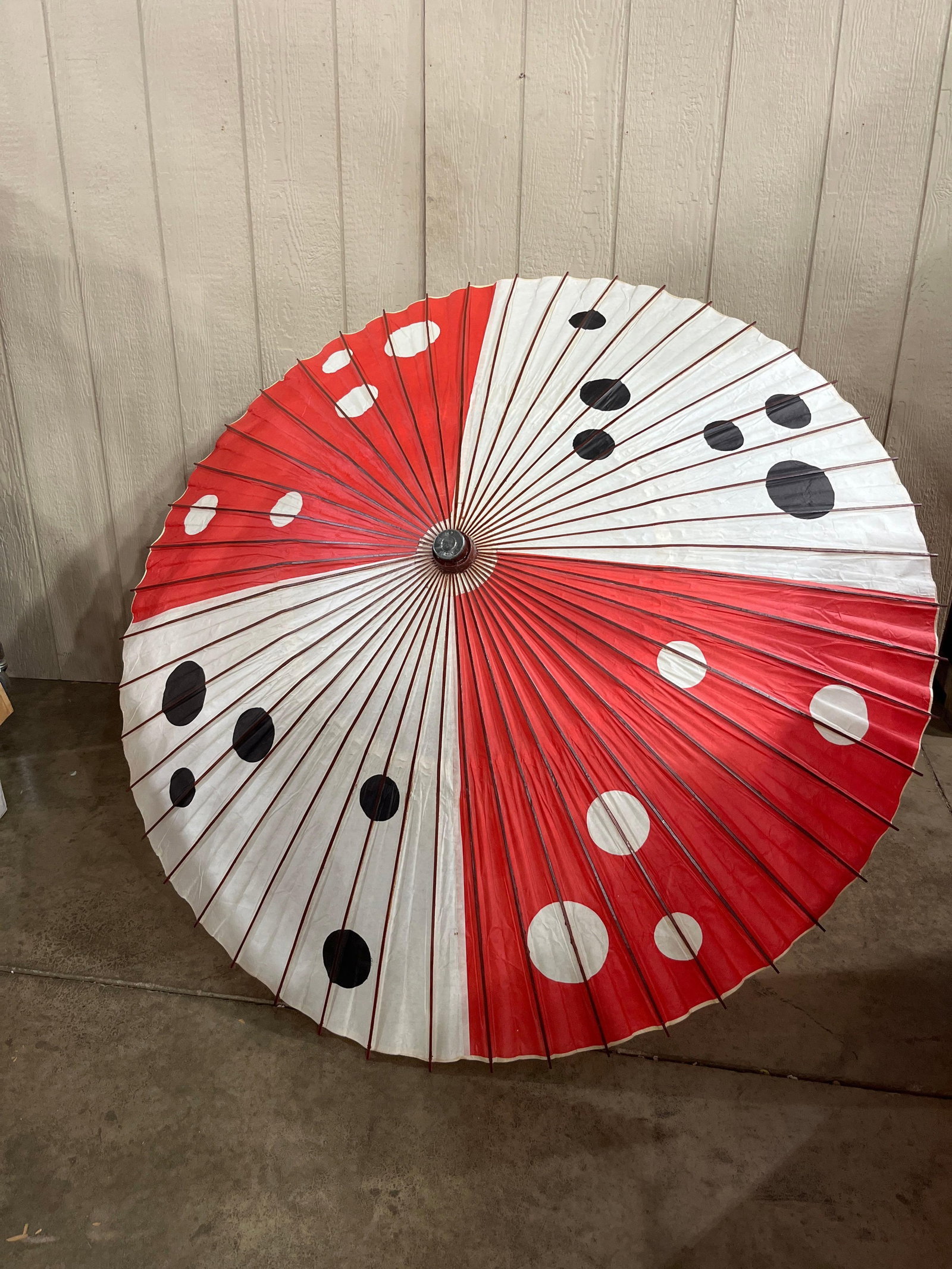 Japanese Wagasa Polka Dot Paper Parasol: A Japanese paper parasol, often referred to as a wagasa, featuring an oiled paper canopy over a multi-ribbed bamboo and wood frame. The decorative design consists of alternating red and white quarter-