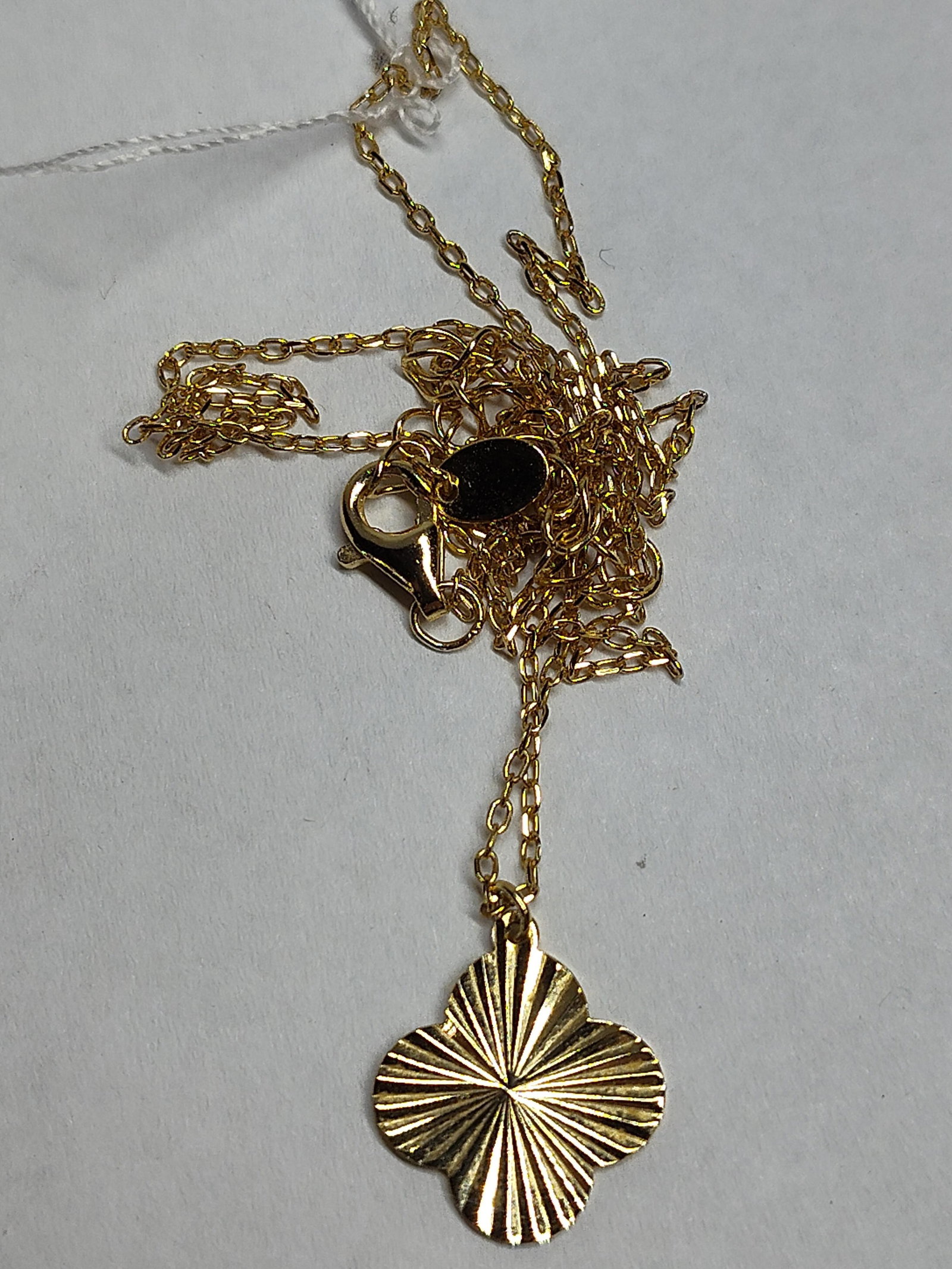 Gold-Plated Str. Quatrefoil Necklace: This necklace is crafted in gold-plated sterling silver and features a fine cable link chain with a single pendant. The pendant is designed in a quatrefoil or stylized four-leaf clover shape,