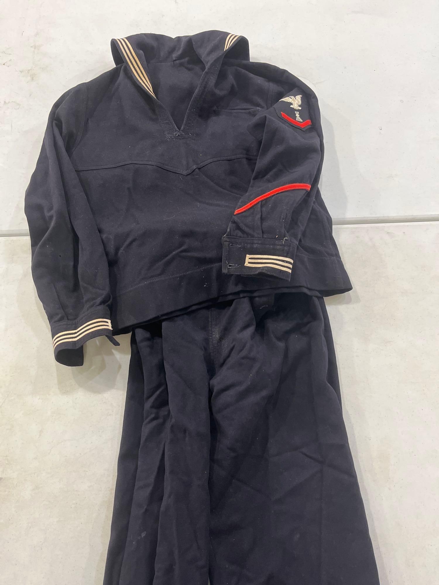 Mid-20th C. USN Dress Blue Wool Uniform: A two-piece United States Navy enlisted man's dress blue uniform set, commonly referred to as the crackerjack style. The set is comprised of a pullover jumper and matching broadfall trousers. The