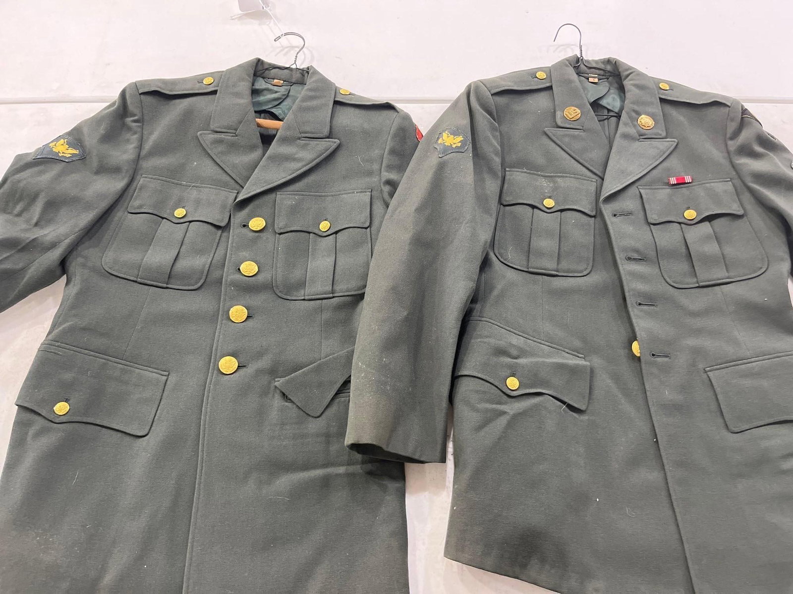 Pair U.S. Army AG-44 Spec 4 Jackets: Two vintage U.S. Army Men's Green Service Uniform (AG-44) Class A service coats, dating from the mid-1950s through the 1970s. Both jackets are constructed of wool-blend fabric and feature a